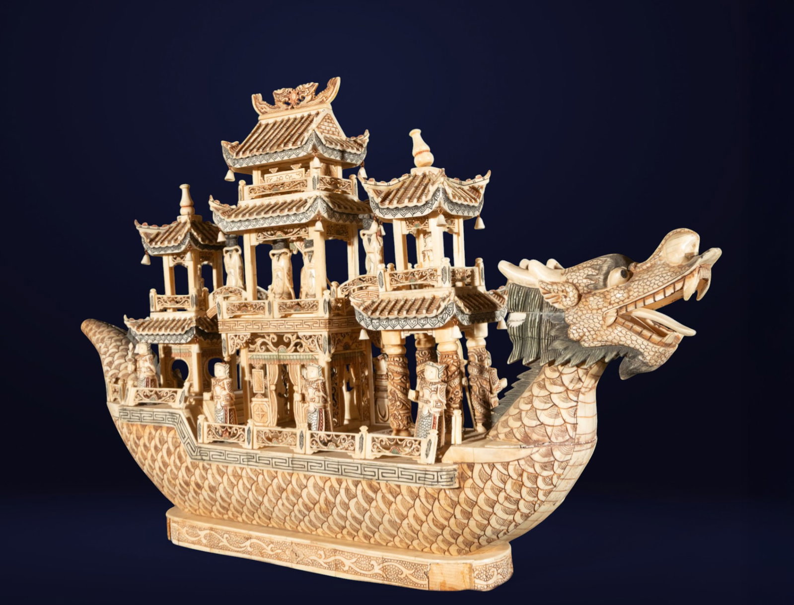 Chinese boat with bone figures. Oriental School. 20th century.: Hand-carved bone. Dimensions: 60 x 100 x 22 cm. Impressive sculpture in the form of a traditional Chinese boat, whose hull takes the shape of a dragon, a symbol of imperial power and good fortune. The