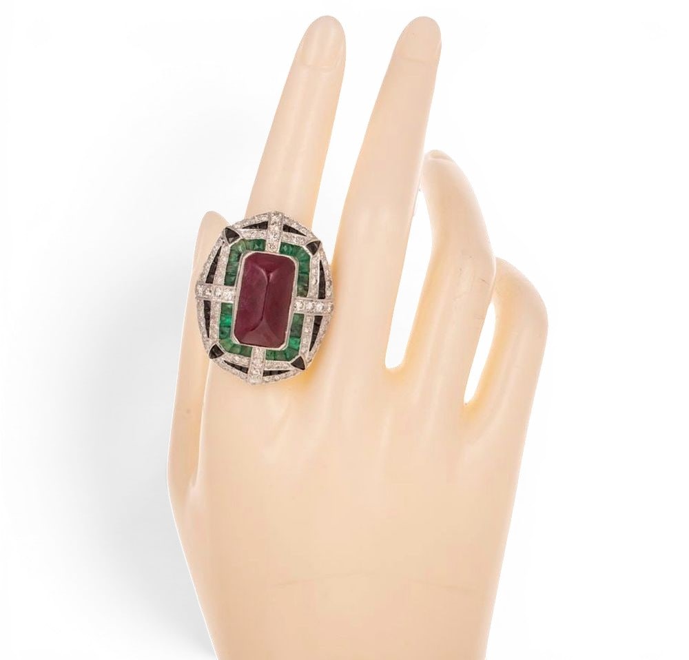 Ring with central ruby, emeralds, onyx and diamonds: A geometric band ring crafted in silver with a gilt finish, featuring a rectangular-cut natural ruby ??weighing approximately 10 carats, framed by a composition of onyx and emeralds, all enhanced by b