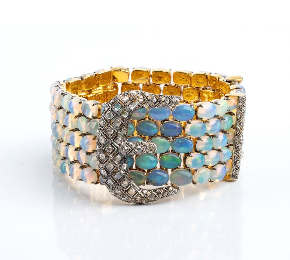 Important Art Nouveau wide bracelet in 18k gold with opals and diamonds: A rigid, articulated bracelet crafted from silver with a full gilt finish. Its wide design features a surface covered with a composition of opals and rose-cut diamonds. It boasts approximately ninety-