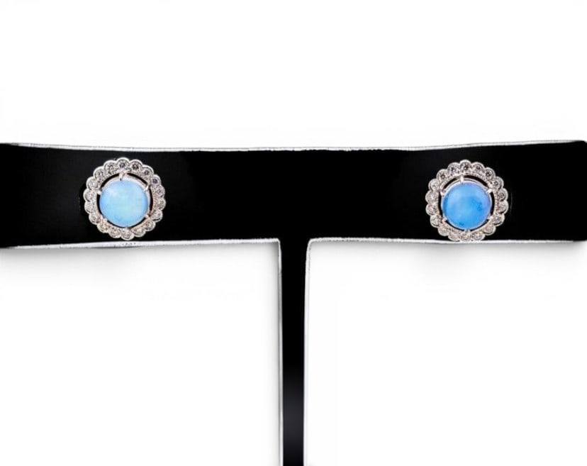 Pair of earrings with opals and diamonds: Pair of earrings crafted in 14-karat gold, featuring a classic design with a central opal surrounded by brilliant-cut diamonds. Each earring features one opal, totaling two opals with an approximate c