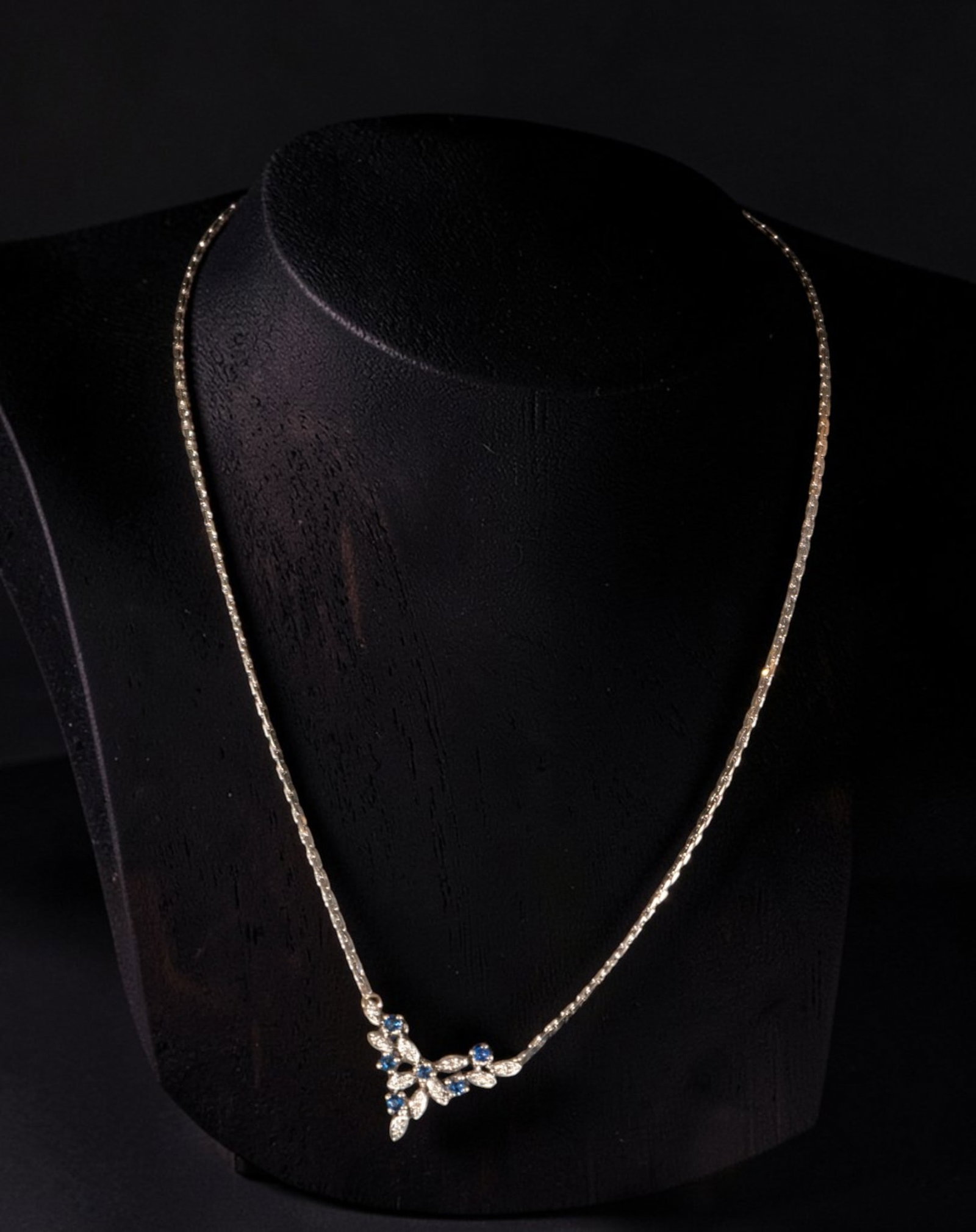 18k white gold choker adorned with brilliant cut sapphires, piece 1920, weight 8.15g: 18k white gold choker adorned with brilliant-cut sapphires, piece from 1920, weighing 8.15 grams. The design features a delicate chain leading to a central openwork motif of vegetal motifs, articulate
