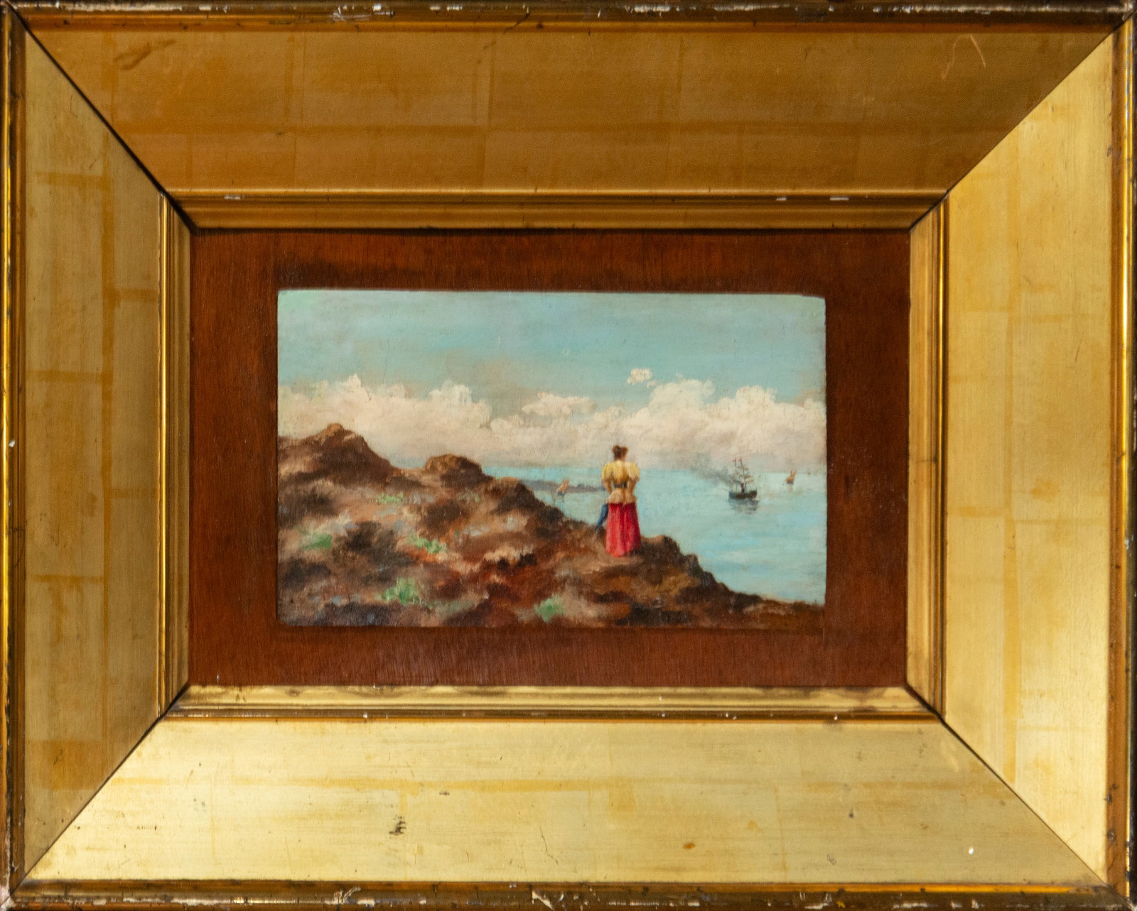 Seascape with female figure against the coast, Spanish school, 19th century: Oil on panel. Dimensions 27 x 16 cm; framed 55 x 41 cm. A small seascape in which a female figure, seen from behind, is silhouetted against a rocky foreground, facing a stretch of calm water where sev