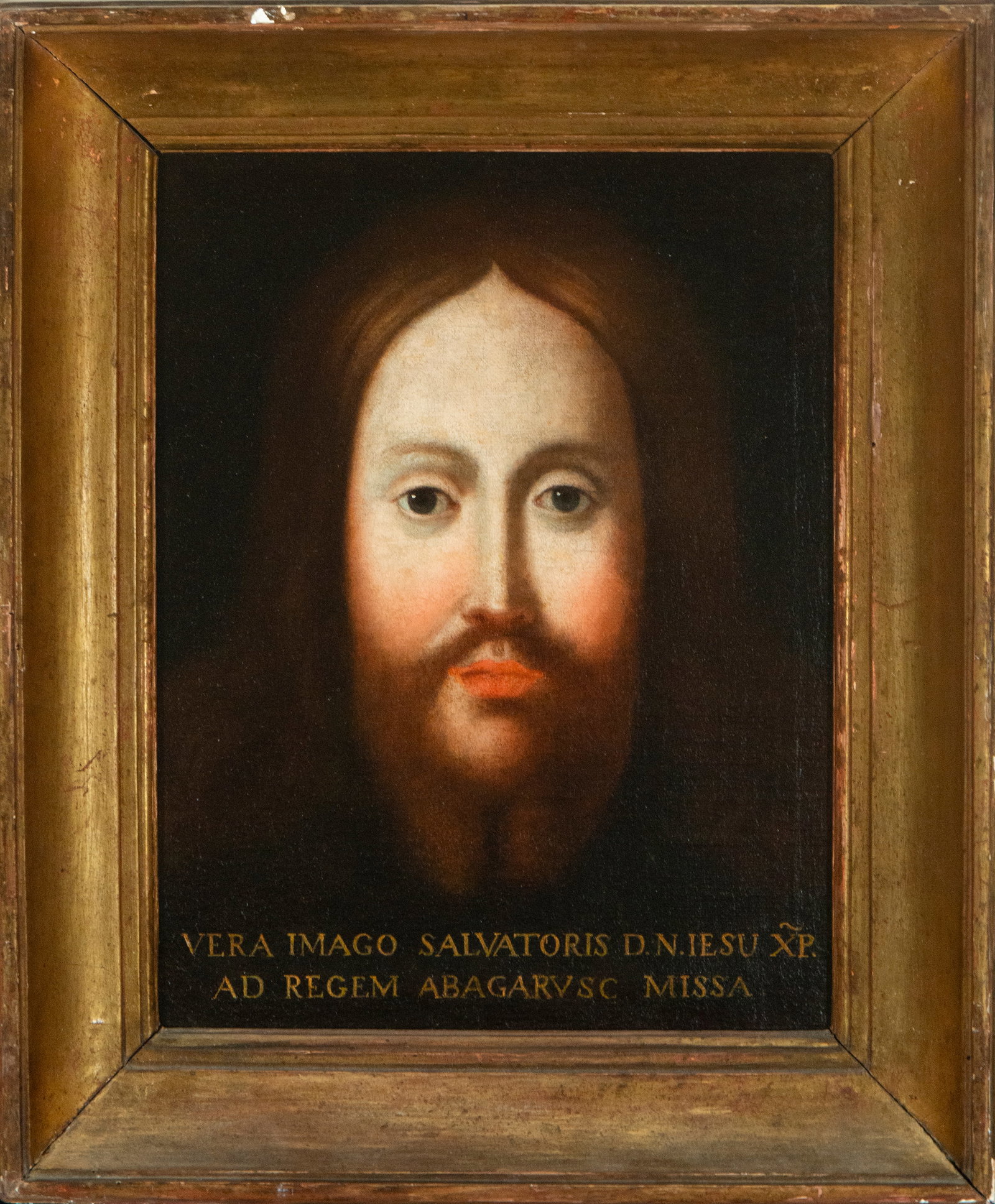 True effigy of Christ the Savior. 17th-century Spanish Colonial Viceroyalty School: Oil on canvas. Dimensions: 38 x 30 cm. The image shows the face of Christ against a black background, with long hair, a beard, and a direct, serene, and penetrating gaze. Beneath the image, a Latin in