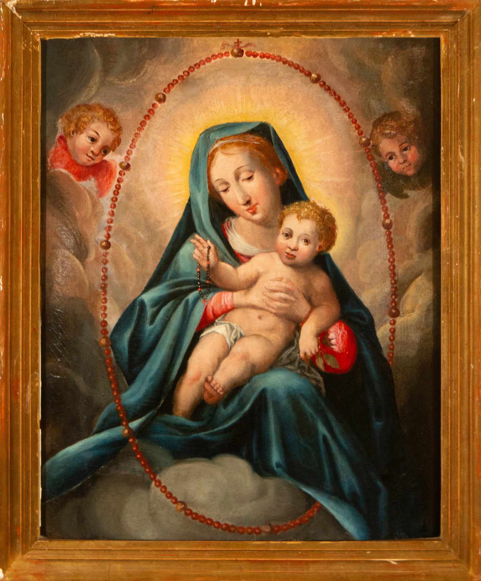 Virgin of the Rosary. 16th-century Italian-Flemish school: Oil on panel. Dimensions: 65 x 52 cm. The Virgin, enthroned among clouds, holds the Child Jesus on her lap while both hold a rosary, whose oval shape frames the scene as a symbol of continuous prayer 