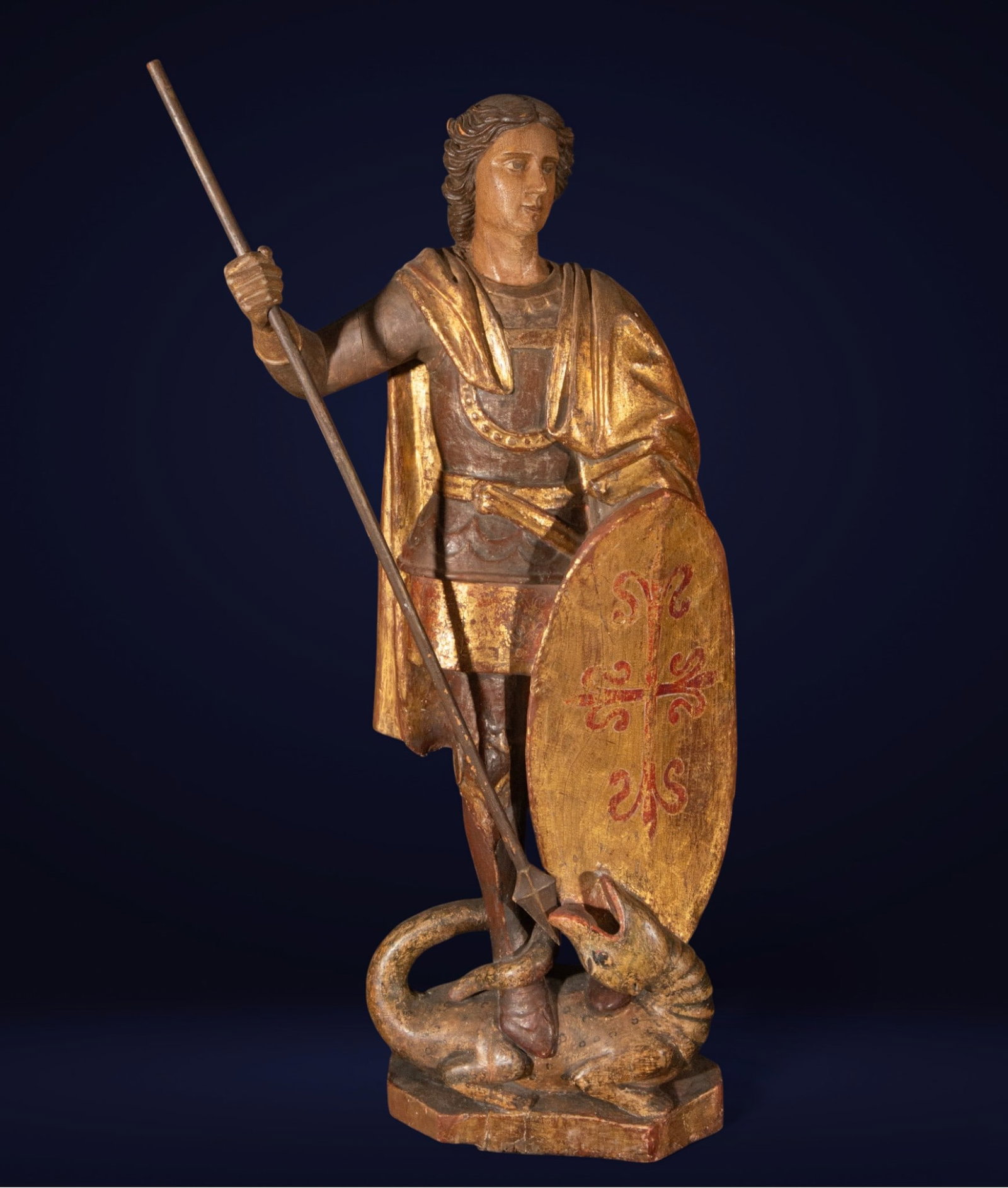 Important St. George, Austria, 16th century - Renaissance: Carved, polychromed, and gilded wooden sculpture. Measures 93 cm x 50 cm x 24 cm. The figure of Saint George stands serenely, clad in armor and a golden cloak, holding a long lance and an oval shield 