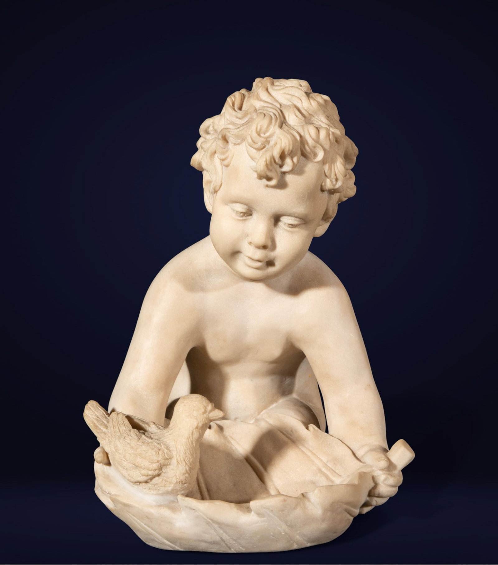 Boy with bird in marble nest, Italy - 19th century.: Alabaster. Measures 40 x 30 x 31 cm. Nude child figure, seated and slightly leaning forward, with head turned and gaze lowered towards a bird perched in a large, enveloping nest. The hair is rendered 