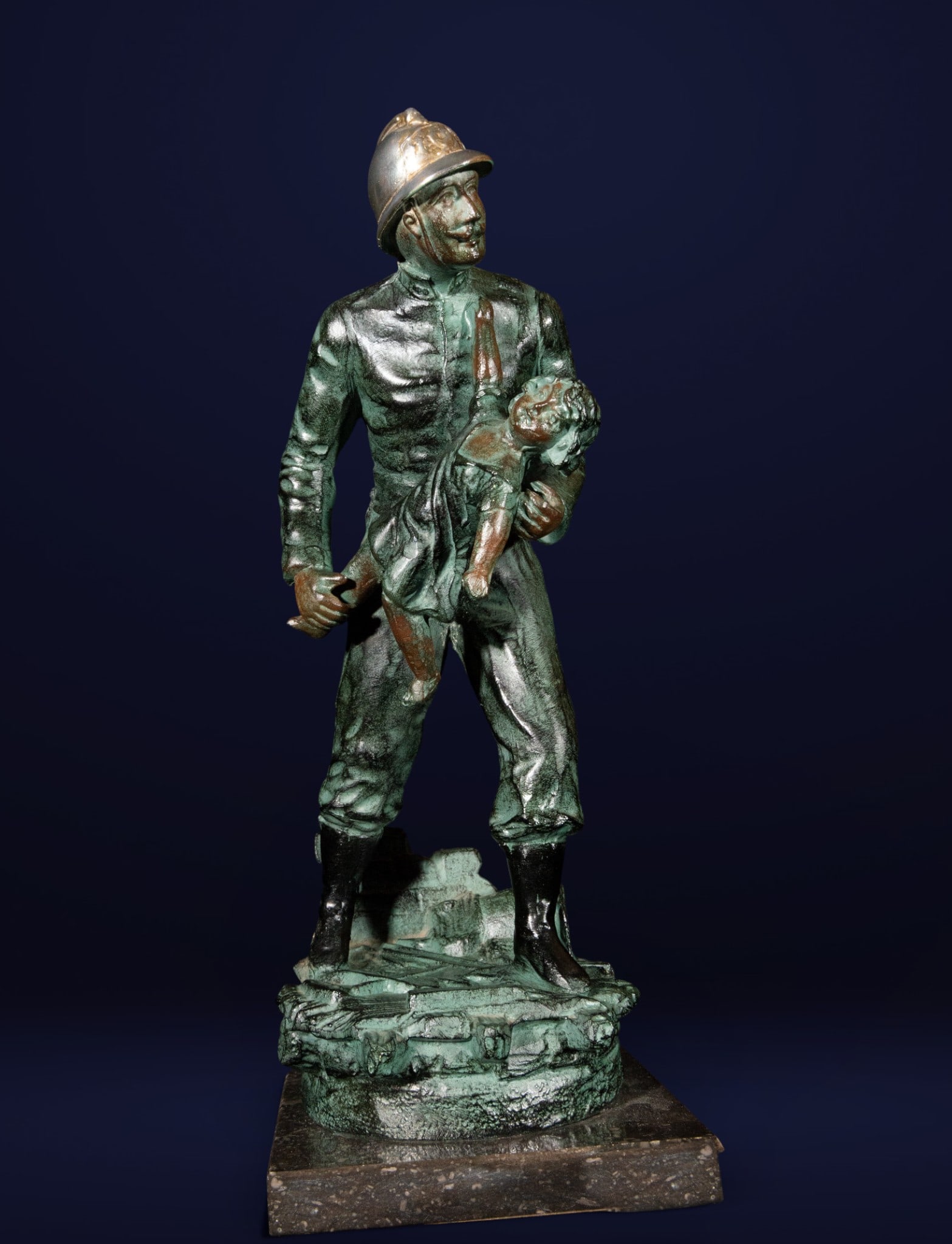 Fireman rescuing a girl. Signed Rucho. Sculpture. 20th century: Signed bronze sculpture. Measures 35 x 16 x 15 cm. Depiction of a firefighter heroically rescuing a girl, with a strong narrative and emotional impact. The detailed modeling and greenish patina lend r