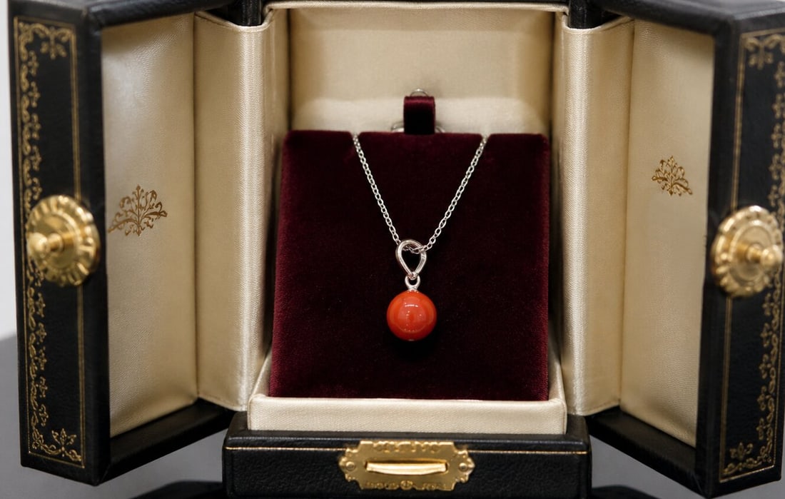 Necklace with a red coral pendant from Sicily. 18-karat white gold. Weight 2.5 grams. Italian: 18-karat white gold and natural red coral from Sicily. Chain length: 42 cm; pendant: 1.5 cm; coral: 7.1 mm in diameter. This Italian jewelry necklace features a delicate chain and a simply designed pe