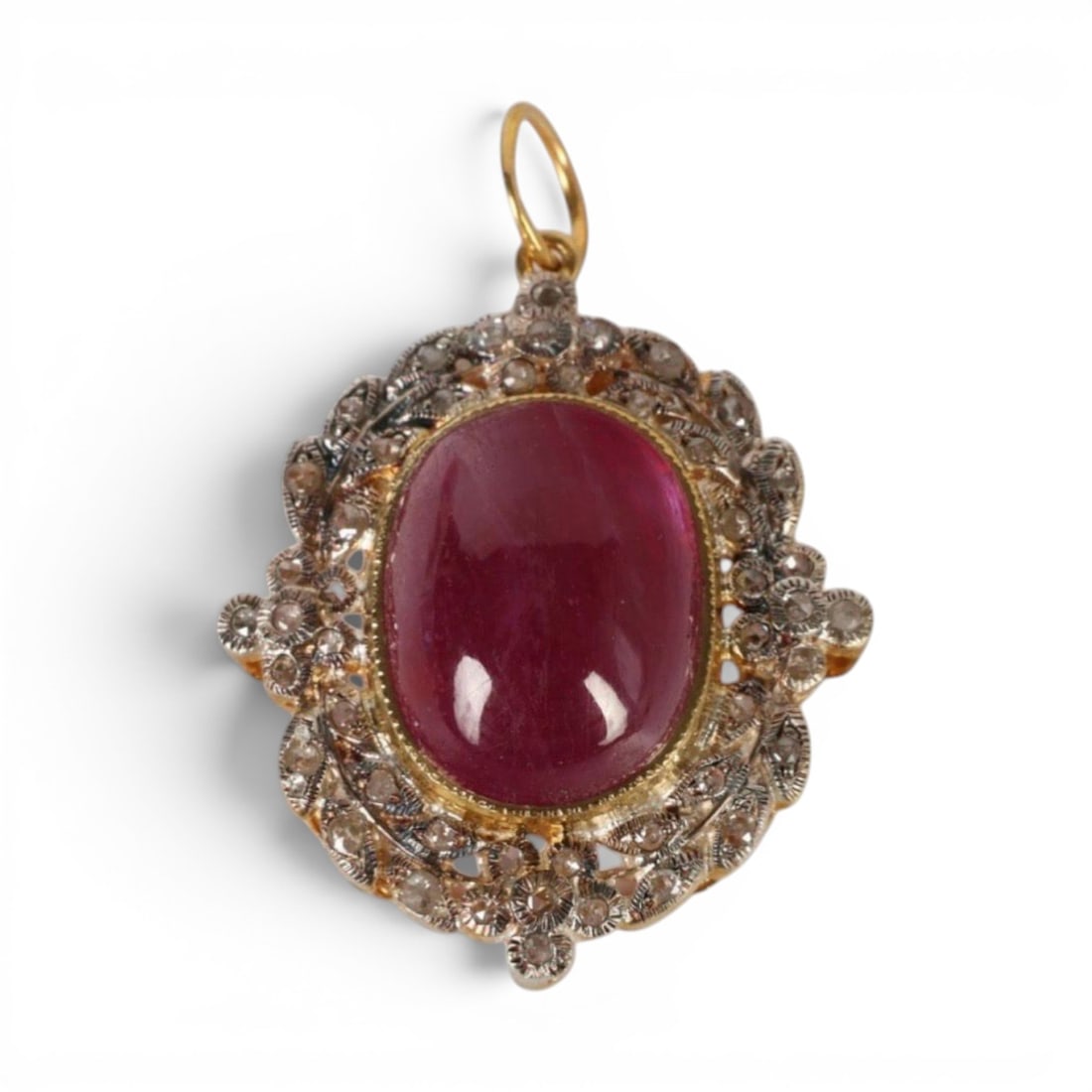 Pendant in silver gilt with natural ruby ??and rose cut diamonds: Partially gilded 925 sterling silver with a 14-karat gold bail, a treated natural ruby, and rose-cut diamonds. This elegant pendant, crafted in partially gilded sterling silver, features a treated cab