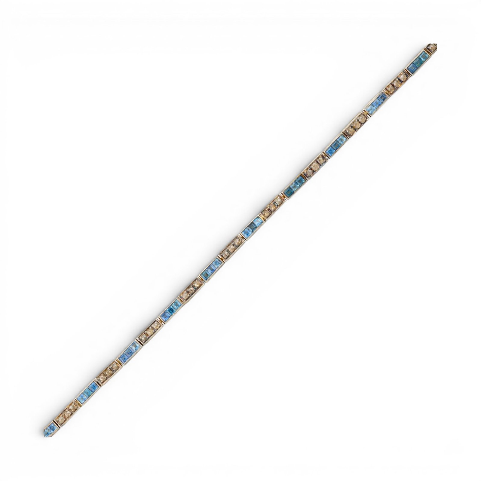 Rivière bracelet in gilded silver with natural sapphires and rose-cut diamonds: Partially gilded 925 sterling silver with a 14-karat gold tongue clasp, natural sapphires, and rose-cut diamonds. This elegant rivière-style bracelet is crafted from partially gilded sterling silver 