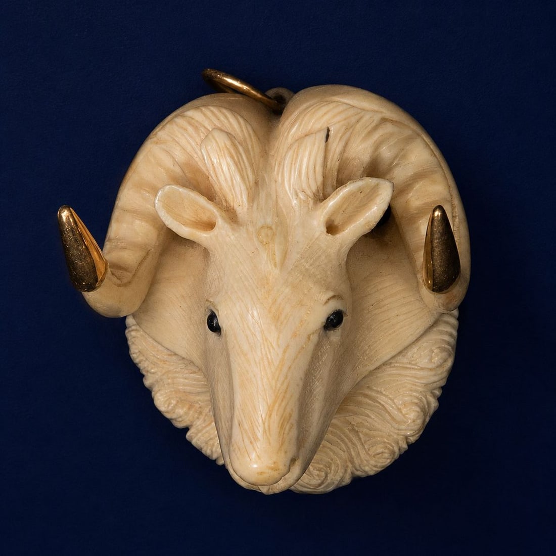 Ram-shaped pendant, European School, 20th century: Fine materials and 18K gold. Dimensions: 5 x 4 x 3 cm. A unique sculptural pendant in the shape of a ram's head, crafted with meticulous carving that emphasizes the animal's anatomy and the dynamism o