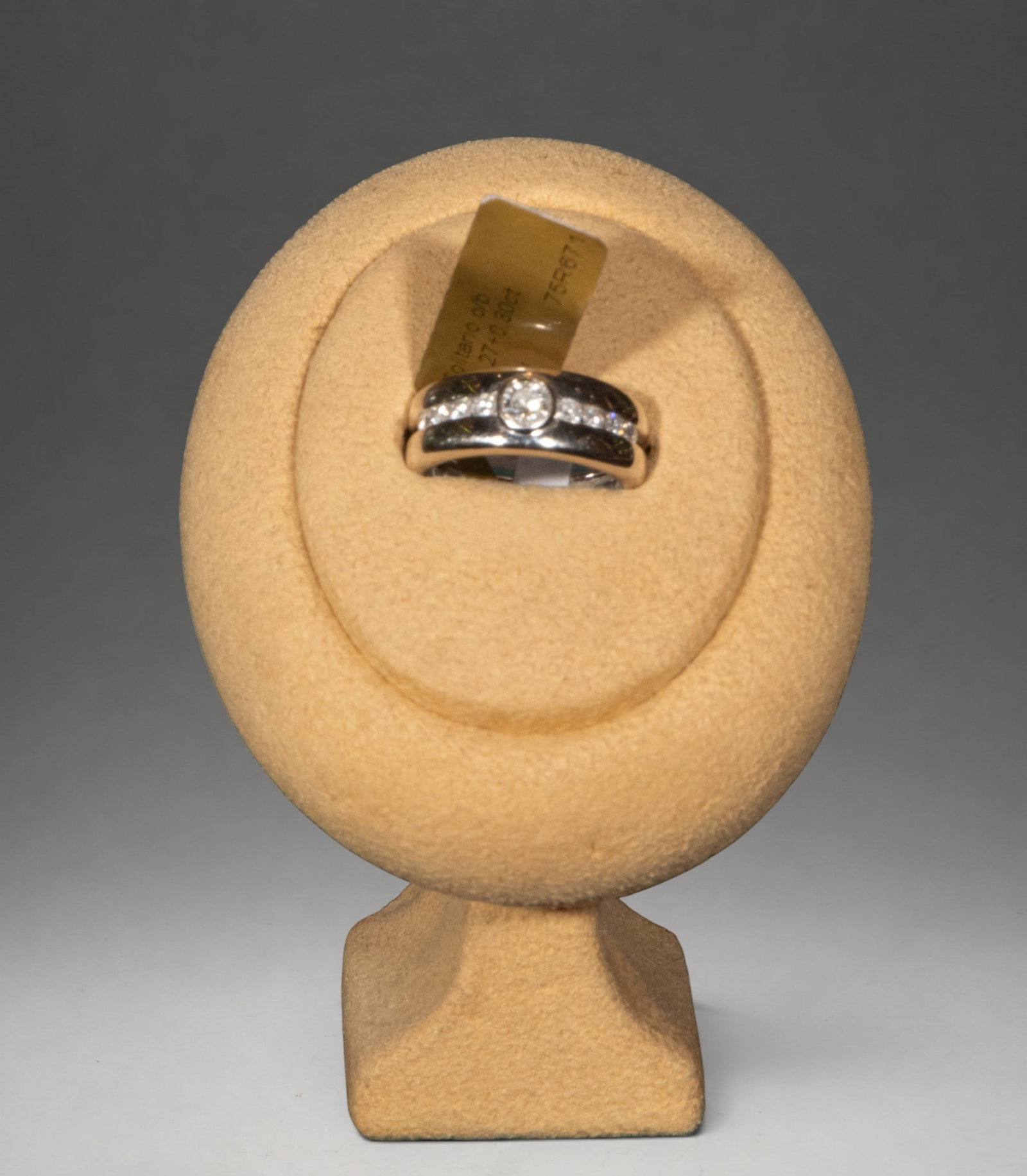 Ring with a diamond solitaire weighing 11.83 g.: Gold ring featuring a brilliant-cut diamond set in a bezel as its centerpiece. The band is adorned with eight brilliant-cut diamonds, with an estimated total weight of 0.57 ct. Total weight of the pie