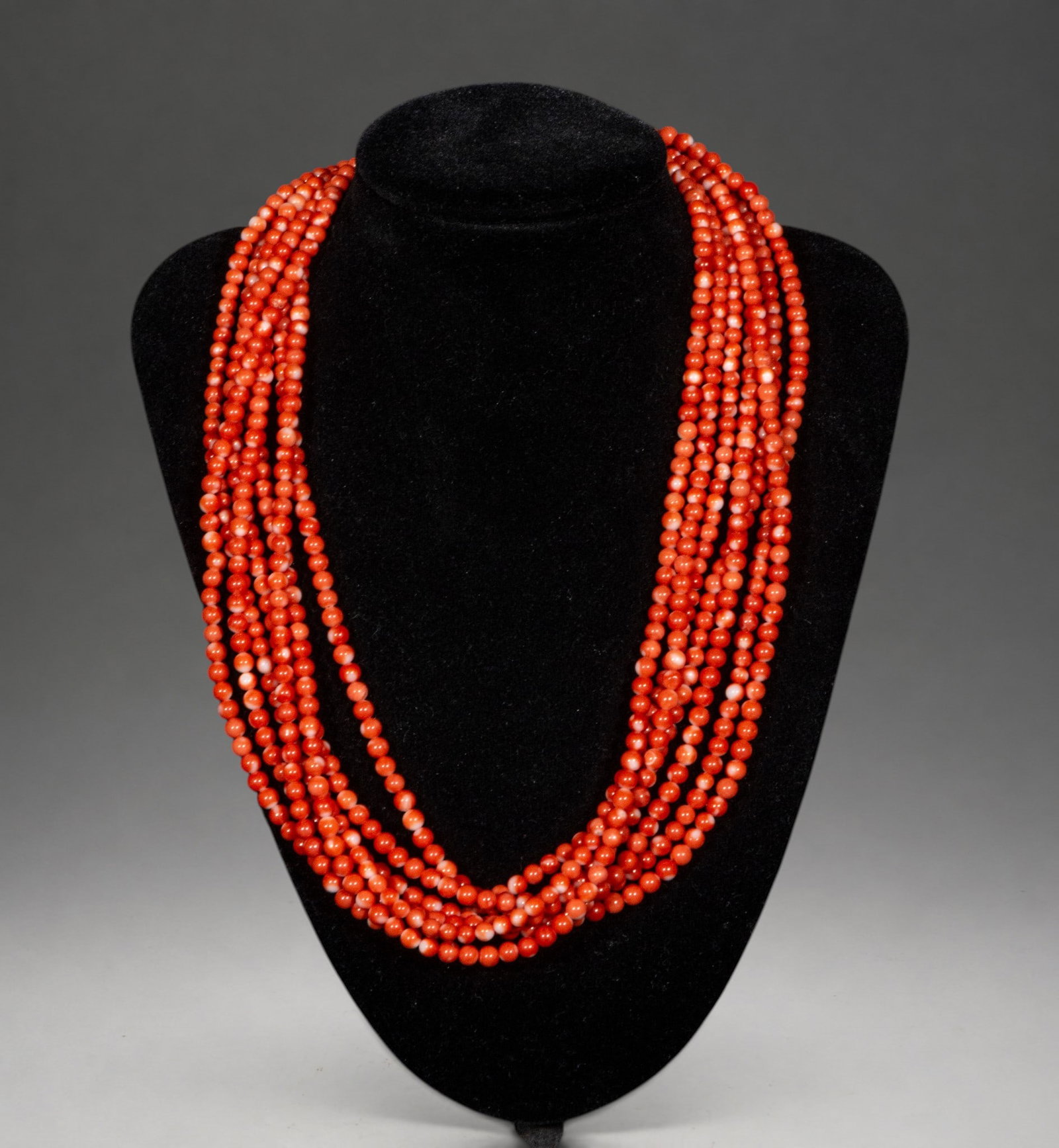 Seven-strand coral necklace: A spectacular necklace composed of seven strands of small natural coral beads, creating an effect of great volume and ornamental richness. The arrangement of the strands provides an elegant drape and 