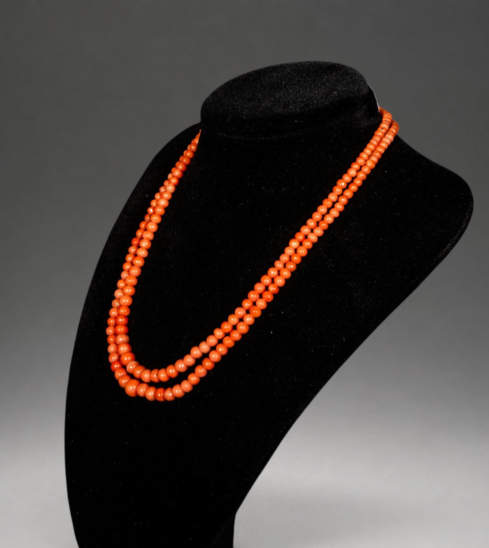 Two-strand necklace of diminishing coral with a low gold clasp: This necklace features two strands of decreasingly sized natural coral beads, finished with a low-karat gold clasp that adds both functionality and elegance. The bead gradient enhances the overall har