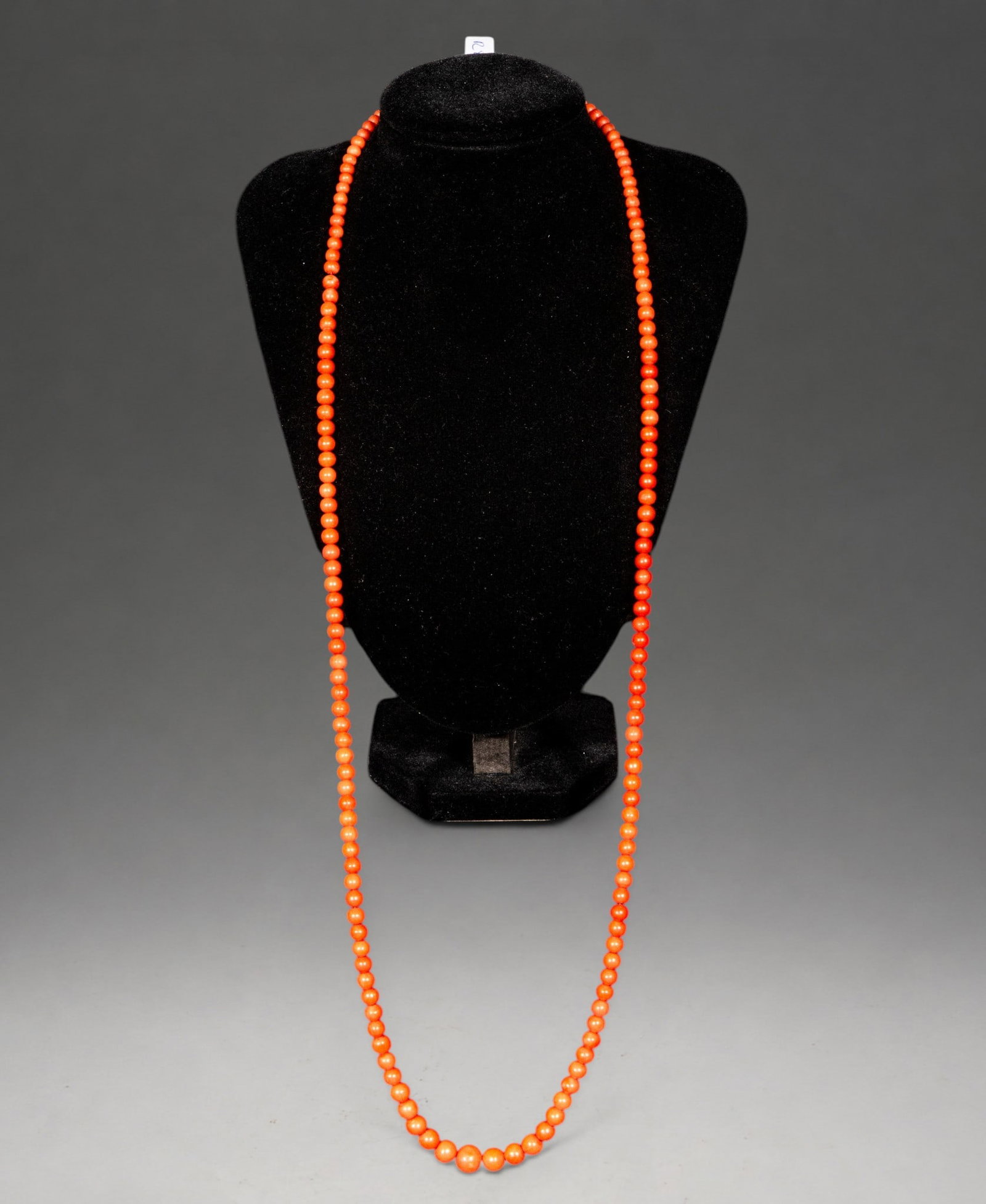 Long coral necklace with a tapered design and 18k gold clasp, 22.4g: Long necklace made with gradually decreasing spherical beads of natural coral, finished with a gold clasp. The balanced gradation of the beads adds elegance and highlights the coral's vibrant color, r