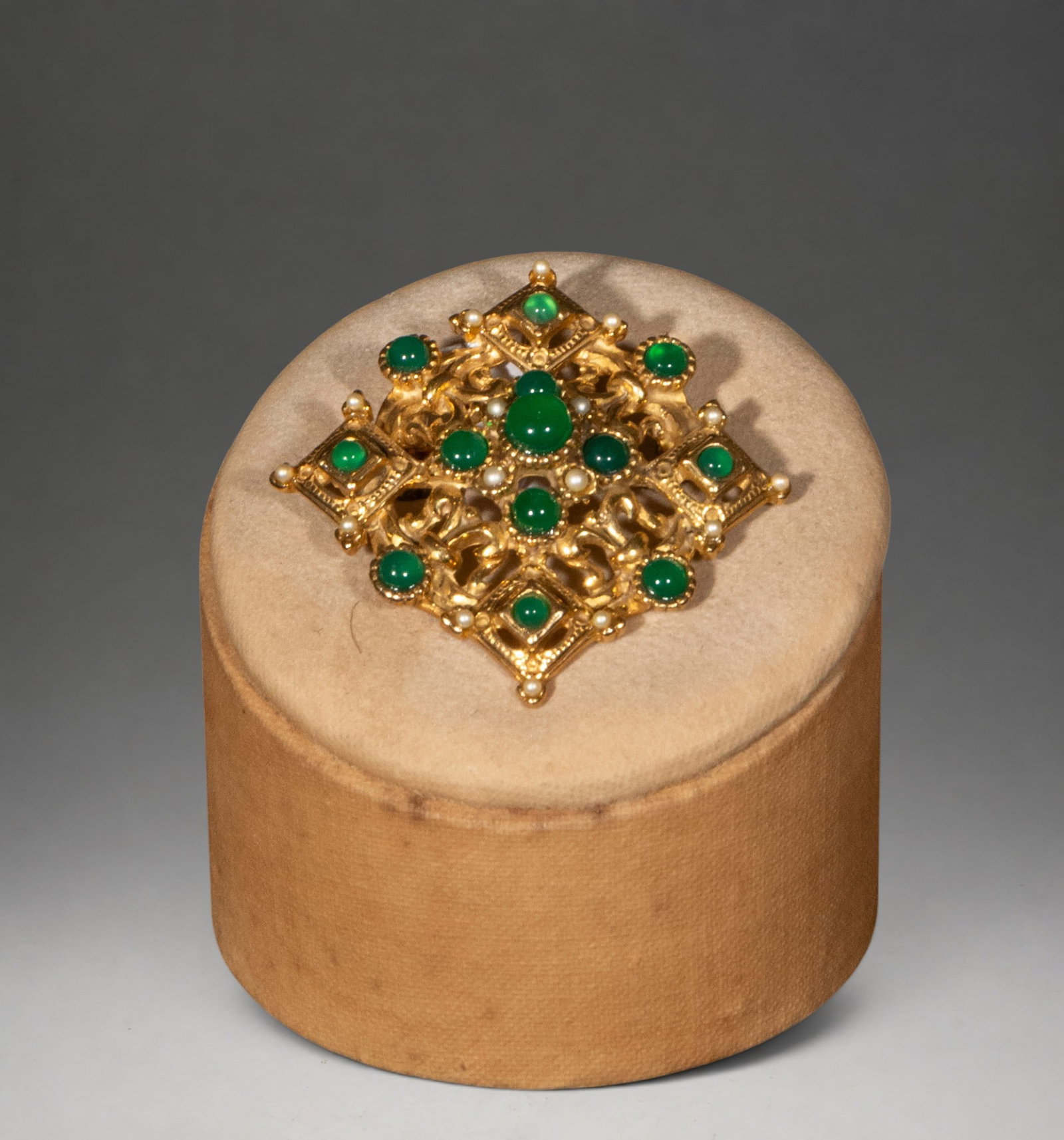 Gilded silver brooch with agates: A gilt silver brooch with a geometric and openwork design, decorated with numerous green agate cabochons and small pearls. The composition stands out for its ornamental balance and its distinct Neo-Re