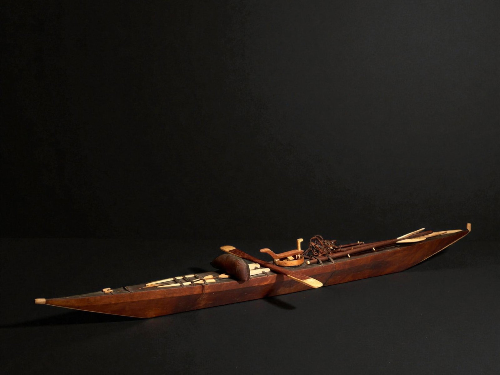 Model of an Inuit kayak with a wooden frame and sealskin covering, Canada, circa 1930–1940: Wood, bone, and sealskin. Dimensions: 155 × 12 × 12 cm. Exceptional Inuit model of a traditional kayak, with a wooden frame covered in sealskin and bone details, retaining all its original features.