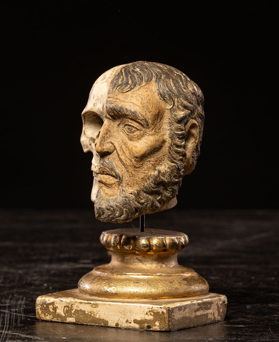 Small memento mori head, Europe, 19th century: Carved wood. Dimensions: 14 x 8 x 8 cm. A small sculpture with strong symbolic content, conceived according to the traditional iconography of memento mori, here resolved by a striking head split in tw