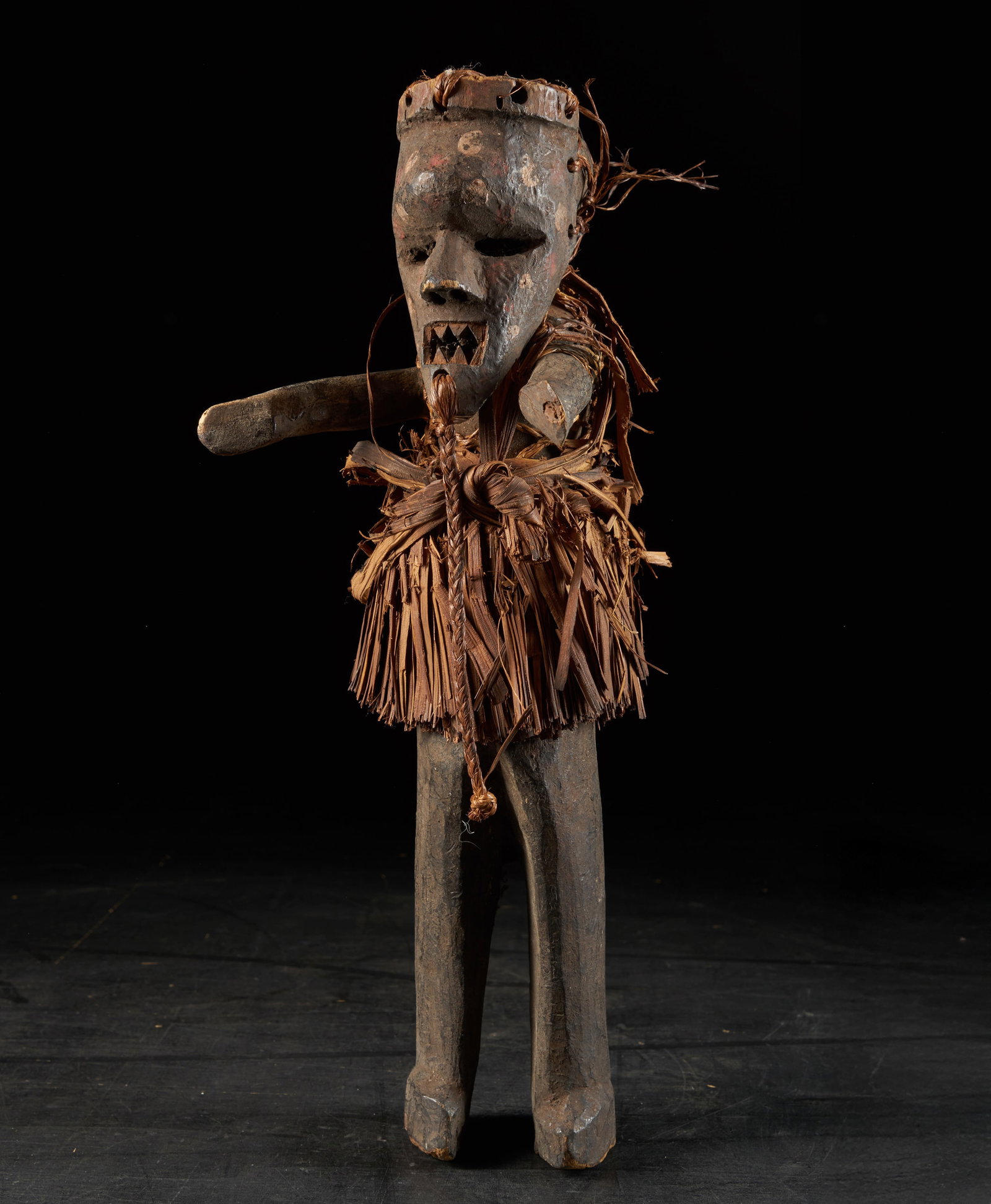 Ritual dance puppet. Salampasu people, Democratic Republic of Congo, 20th century: Wood and plant fiber. Dimensions: 45 cm. Articulated figure used in ritual dances of the Salampasu people, carved from wood and dressed in plant fiber elements, with a conical headdress and a mukinka-