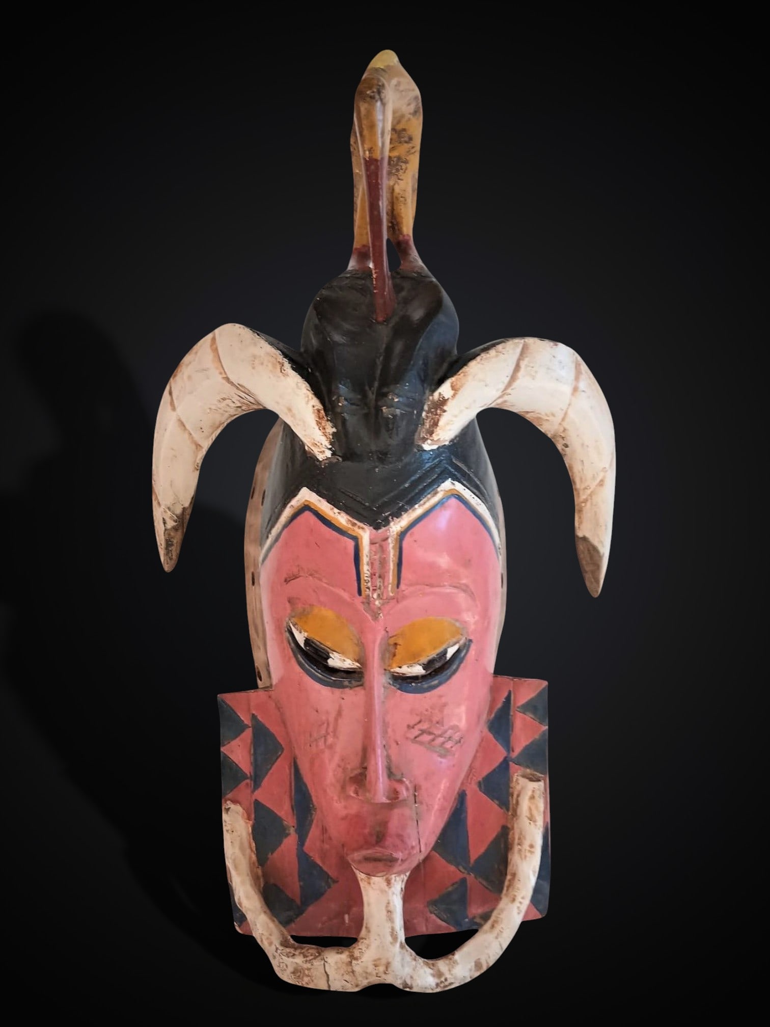 Polychrome ritual mask, Benin culture, 20th century: Carved and polychrome wood. Ritual mask from the Benin culture, with stylized features and preserved color. Dimensions: 48 × 26 cm. Lot in international warehouse (within the EU). Intra-EU shipping: 
