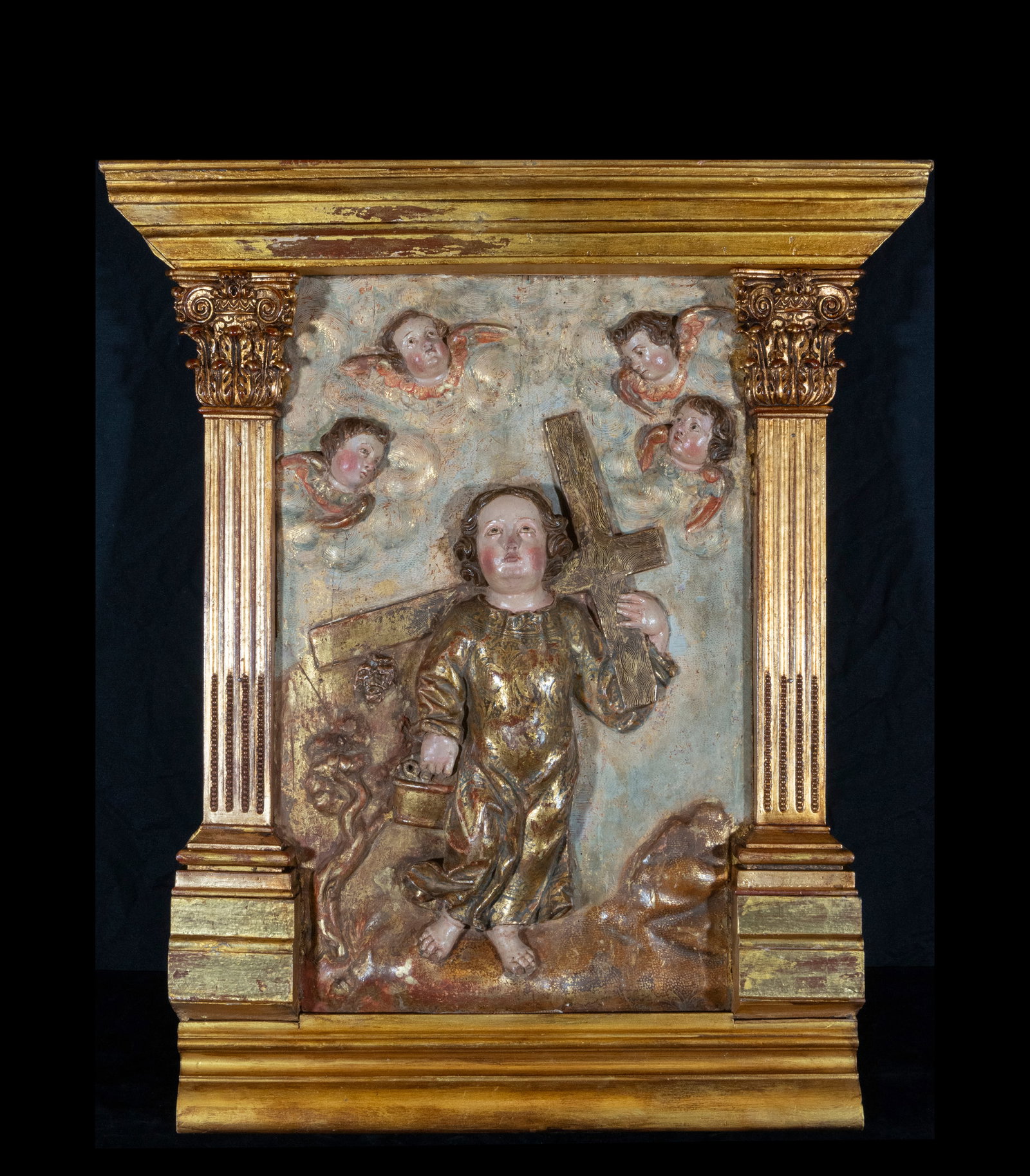 Relief of the Child Jesus carrying the cross - Spanish School - 17th century: Remarkable sculptural relief depicting the Child Jesus carrying a cross, accompanied by cherubs floating above in a heavenly scene. Crafted of polychrome wood, it exhibits a profound wealth of religio