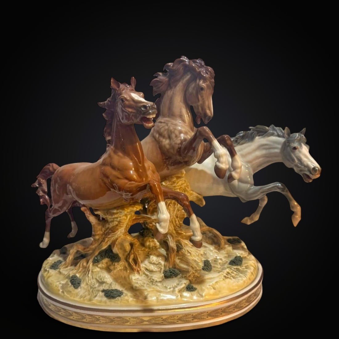 Group of Three Wild Horses. Spanish School. 20th Century: Glazed porcelain. Dimensions 35 x 40 cm. Sculptural group in porcelain by the renowned Spanish firm Algora, depicting three wild horses in dynamic poses upon a naturalistic base. The figures form a hi