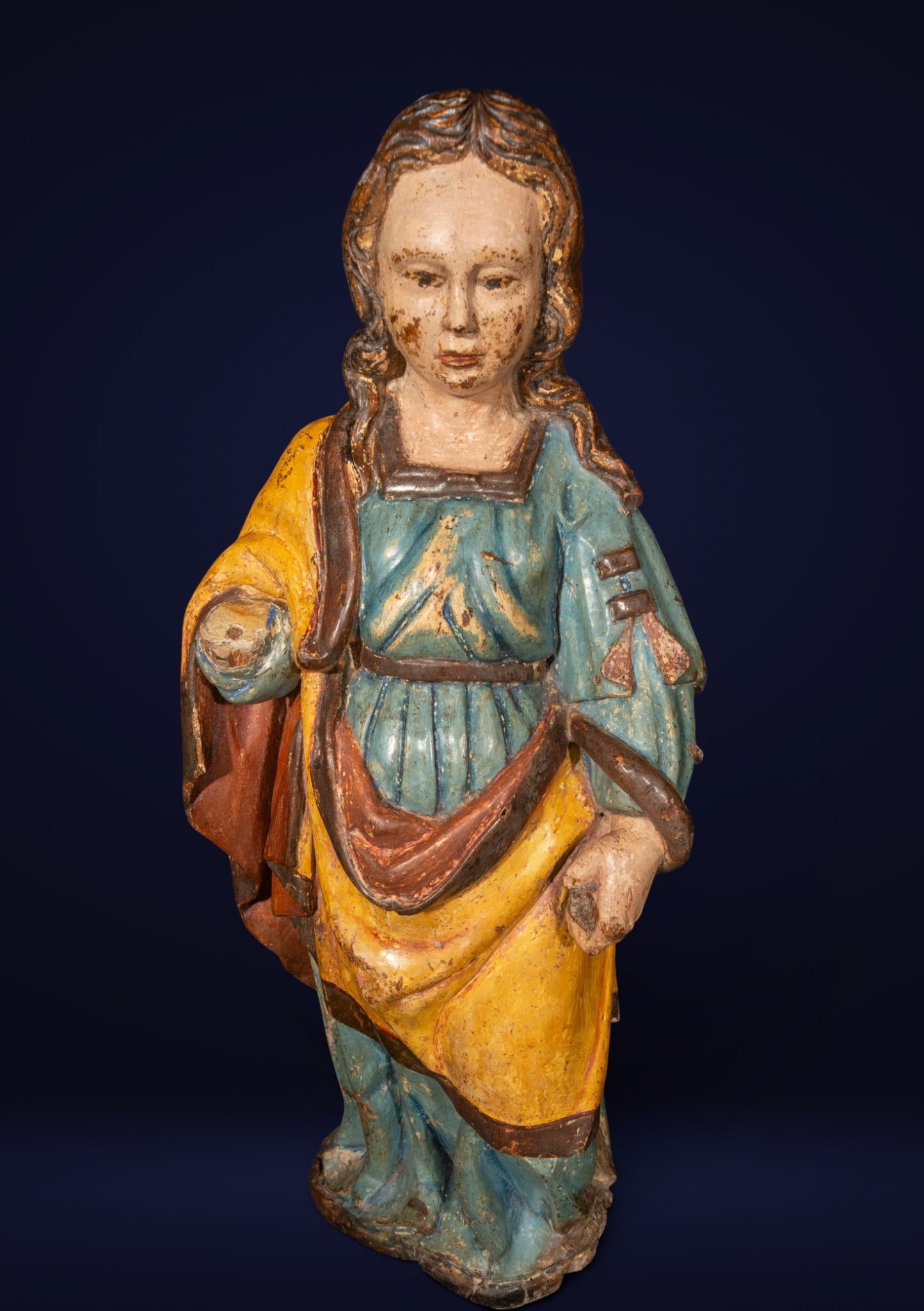 Holy martyr, Hispano-Flemish school, 16th century: Polychrome wood carving. Standing female figure in a blue and yellow tunic, executed with serene frontality and delicate modeling of the face. The piece retains traces of its original polychromy and f