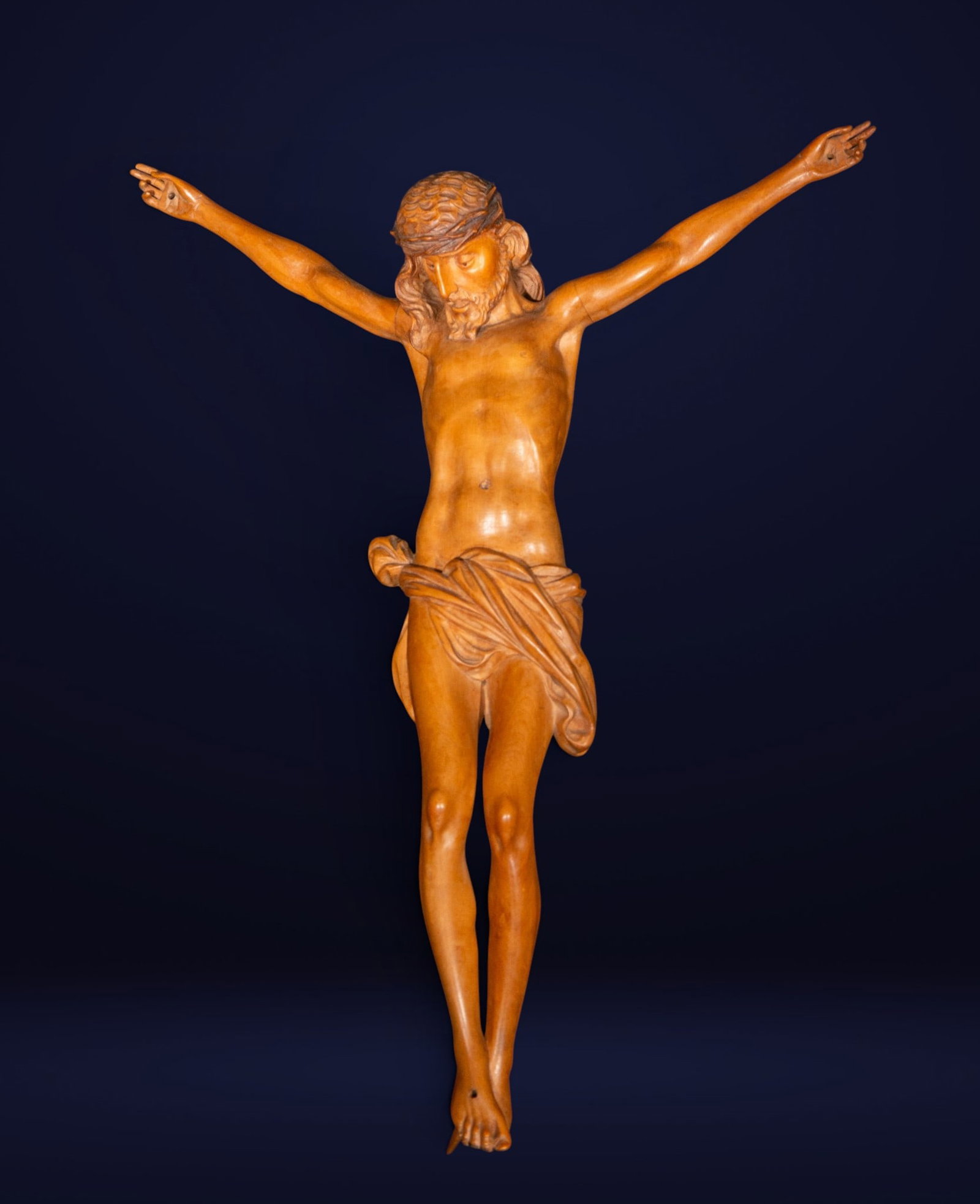 Christ crucified, Spanish school, 18th century: Sculpture in carved fruitwood. Figure of Christ crucified with stylized anatomy and delicate body modeling, with inclined head and a serene expression of profound spiritual contemplation. The carving 