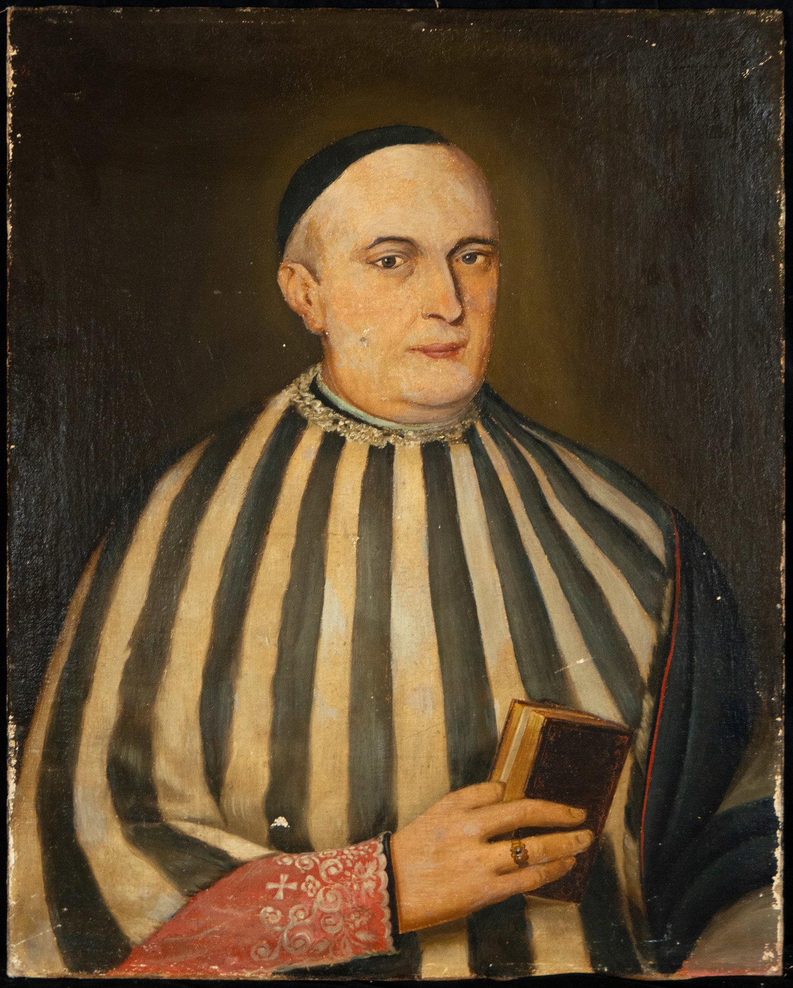 Portrait of a religious figure. Italian Master of the second half of the 17th century: Oil on canvas. Dimensions 72 × 58 cm. Portrait of a clergyman holding a book, with a sober composition and neutral background. The work stands out for the serenity of the figure and the refined treat