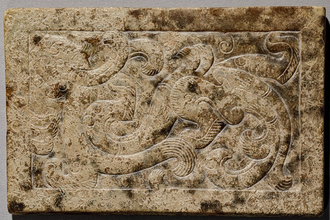 Decorative element with chimera and dragon motifs, Western Han Dynasty, 2nd century BC - 1st century: Light beige jade with brown undertones, carved and chiseled. Measures 11.7 x 7 cm. Rectangular piece decorated on one side with a composition of intertwined fantastical creatures and curvilinear motif