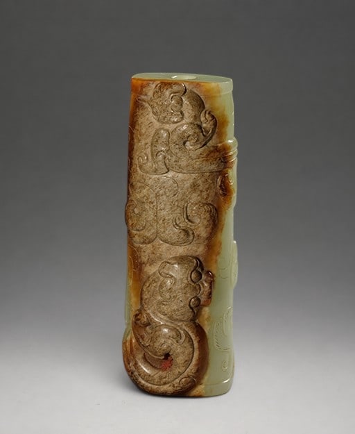 Exceptional Chinese Jade from the Western Han Dynasty, 2nd Century BC. C. - I d. c.: Carved and chiseled celadon jade. Measures 7.7 x 2.8 cm. Slightly flattened cylindrical bead, perforated lengthwise. One side features figures of fantastical creatures facing each other amidst curvili