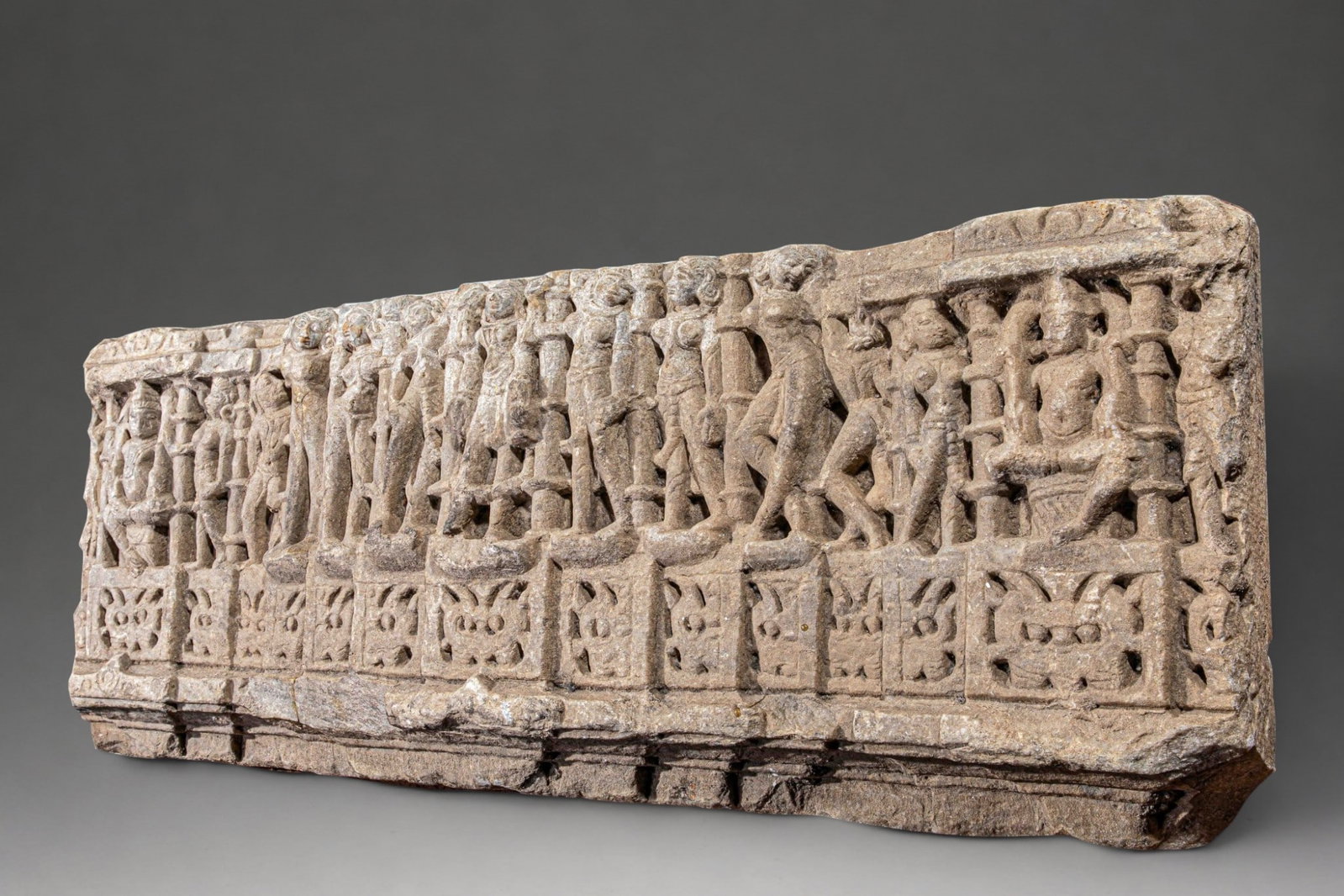 Ancient Indian frieze from the 11th century: High-relief carved stone. Measures 100 x 40 cm. Architectural frieze of a sanctuary composed of a succession of torso-naked apsaras, adorned with tightly cinched dhoti and richly ornamented, arranged 