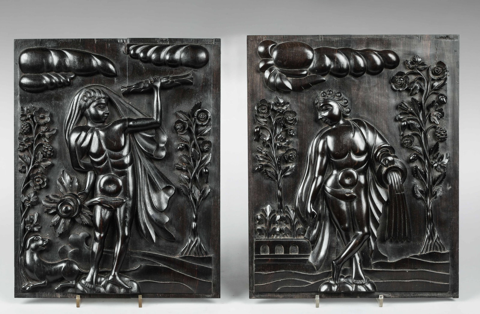 Pair of panels from the Garden of Eden, European School, 17th Century: Rosewood carved in relief. Measures 42 x 33 cm. Pair of decorative panels depicting figures associated with the Garden of Eden, rendered with a stylized and ornamental aesthetic of great visual impact