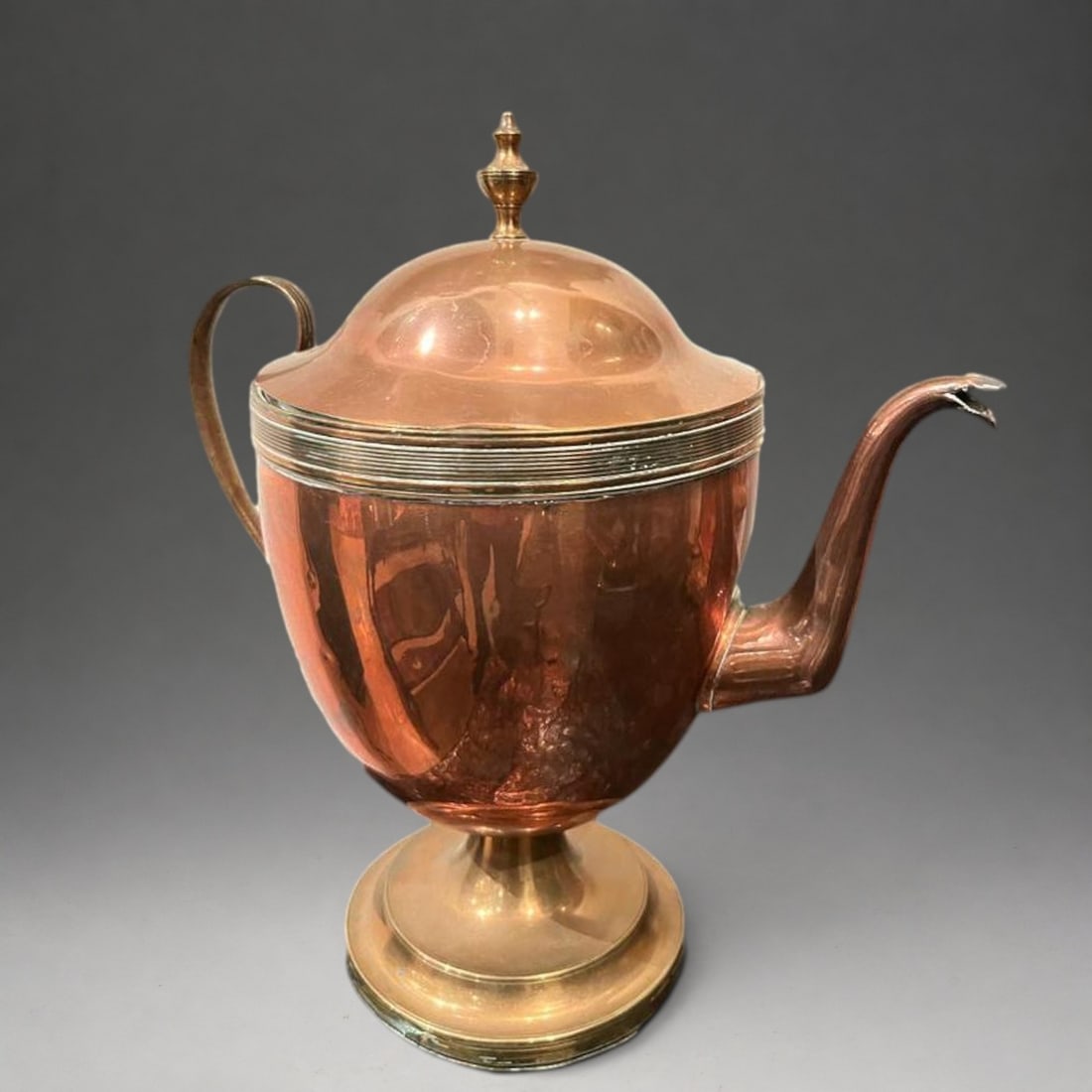 Copper-covered coffee pot or jug: Copper. Measures 31 x 28 x 15.5 cm. Covered pourer on a circular base, with a globular body, domed lid topped with a knob, long, thin spout, and side screw-on handle. The polished surface displays a c