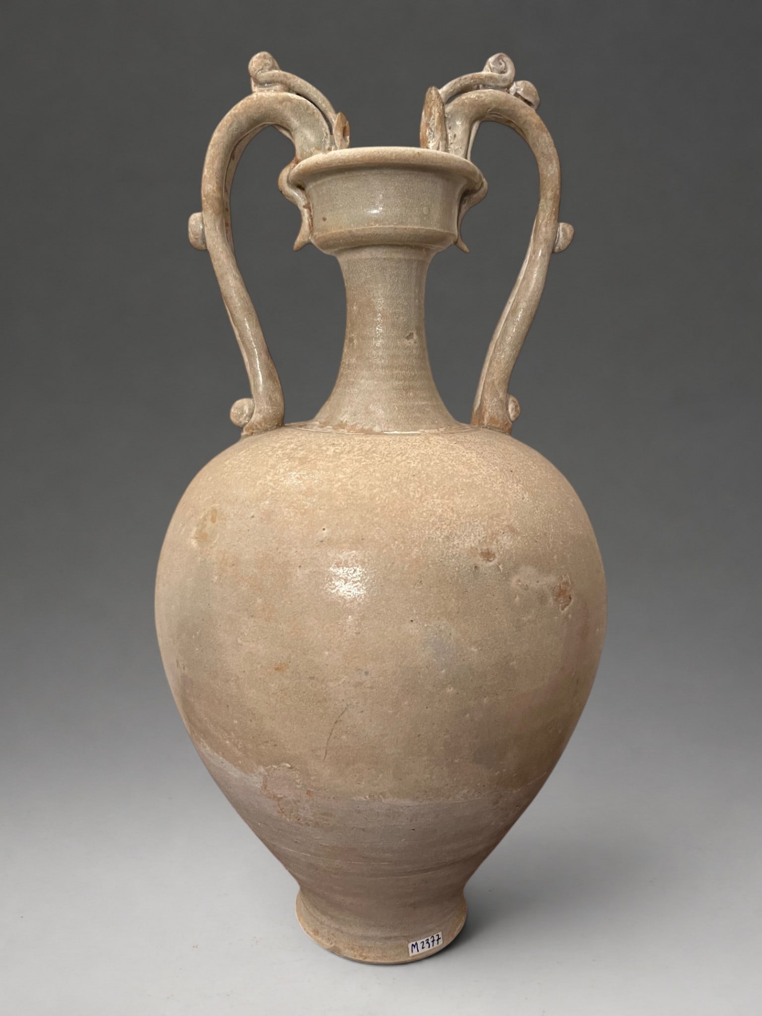 Amphora with zoomorphic handles, Tang Chinese School, 7th-9th century: White stoneware with a cream-colored, crackled glaze. Measures 42 x 20 cm. Large ceremonial amphora with a globular body and raised neck, topped by two imposing handles in the form of stylized dragons