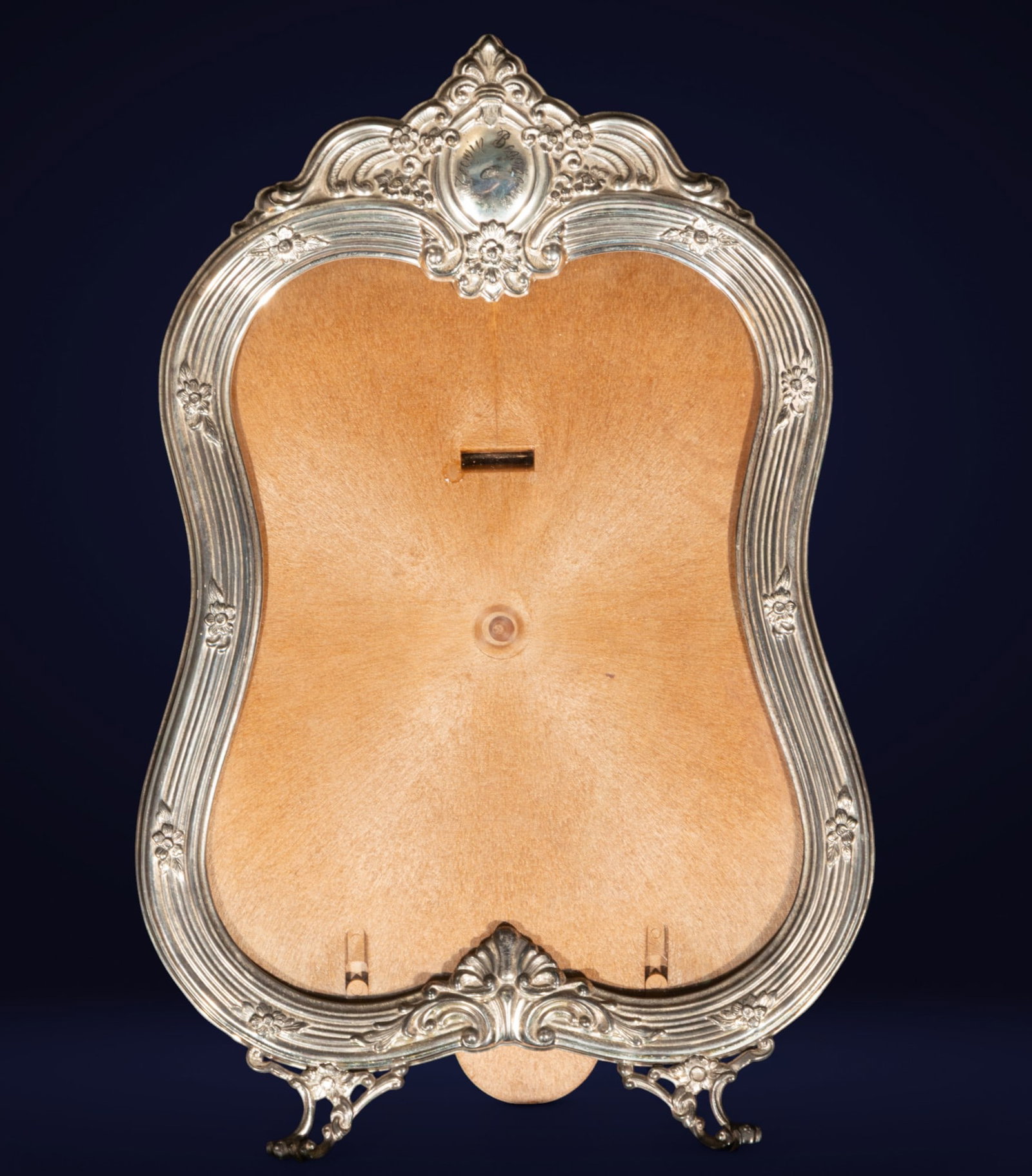 Silver picture frame with wooden back. European School. 19th century.: Tabletop picture frame. Measurements: 31 cm. The frame features a mixed-contour structure in wrought silver with floral decoration and embossed scrolls, crowned by a cartouche bearing a coat of arms. 