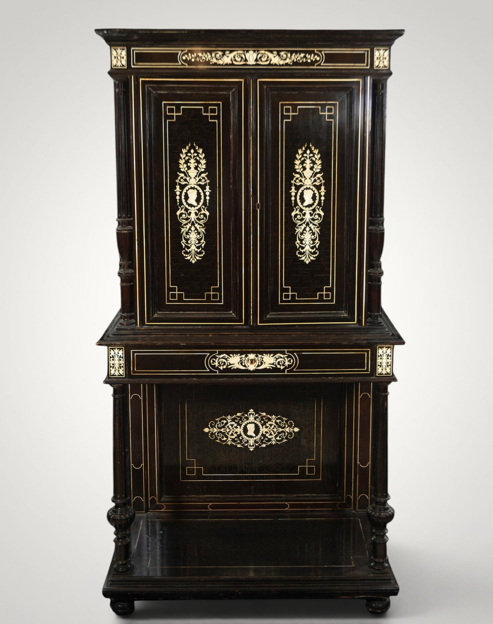Napoleon III inter-bed cabinet - 19th century: Ebonized wood with marquetry and ornamental appliqués. Measures 174 x 86 x 44 cm. Two-section cabinet with a double-door upper section, a middle shelf, and an open lower section, decorated with medal