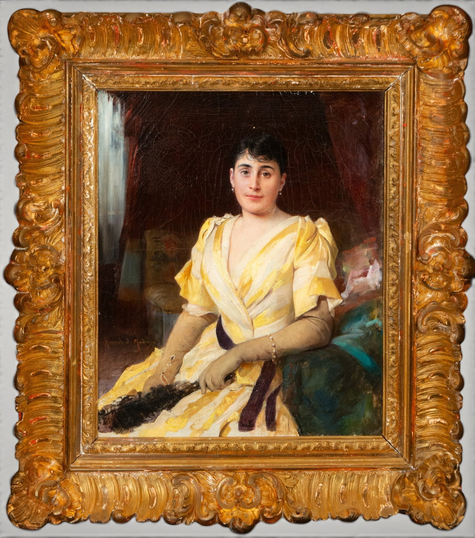 Portrait of a lady in a yellow dress. Spanish School. 19th century: Oil on canvas. Dimensions without frame: 47 x 39 cm. Dimensions with frame: 64 x 55 cm. Seated portrait of a lady in a yellow and white dress, long gloves, and a fan, set against a dark background wit
