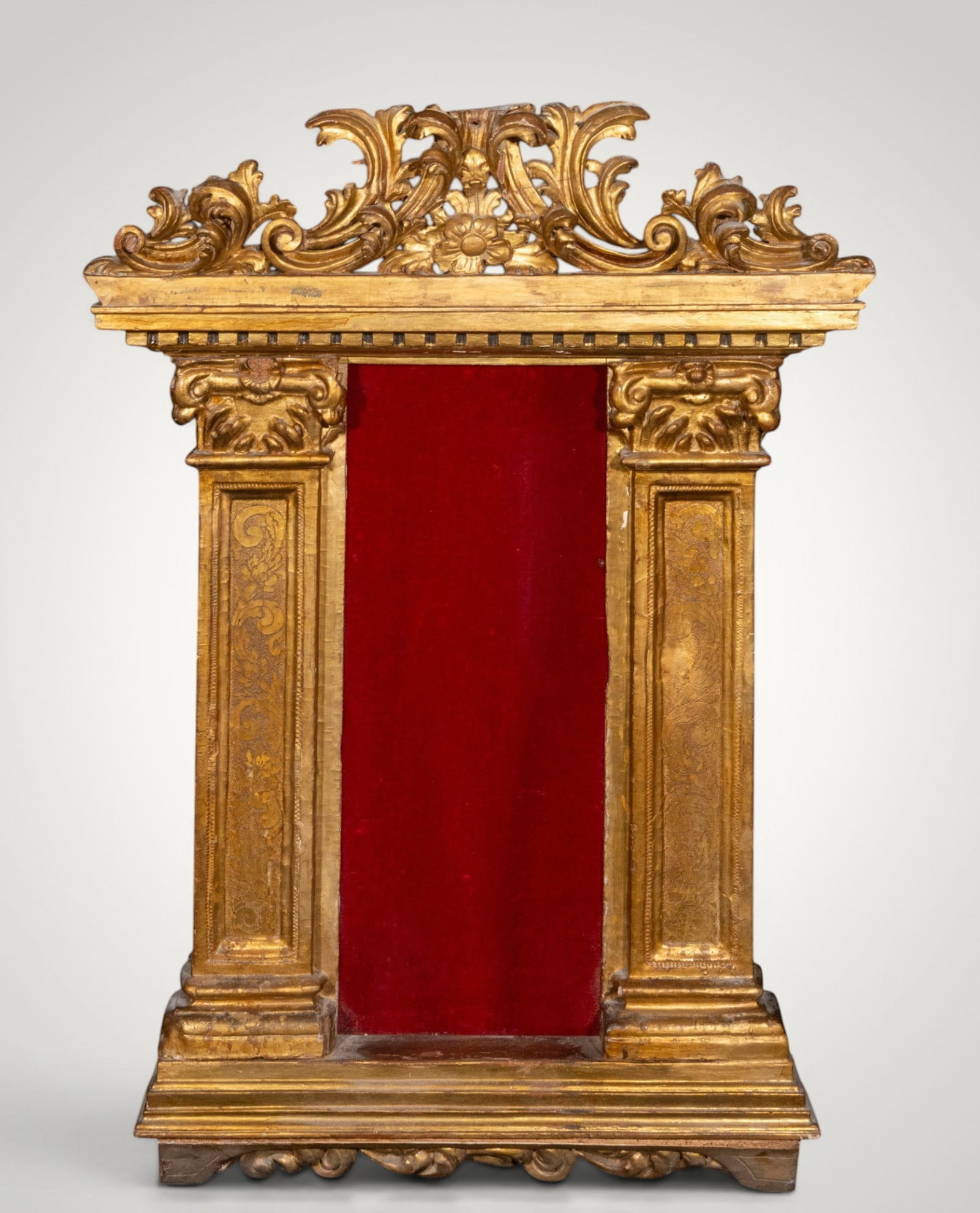 Carved and gilded devotional altarpiece. Spanish School. 18th century: Carved, gilded, and partially polychromed wood. Dimensions: 93 x 69 cm. A single-tiered, single-section devotional altarpiece, conceived with a highly ornamental architectural structure, featuring a c