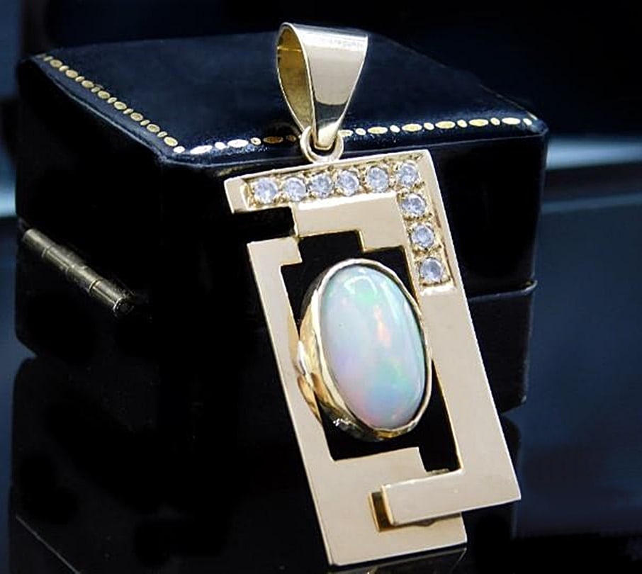 18-karat gold pendant with fire opal and nine diamonds – Andrea Morpurgo, ca. 1990: Vintage unisex pendant crafted in solid 18-karat gold by goldsmith Andrea Morpurgo, circa 1990. Centered by an oval-cut fire opal, stated to weigh 4.57 ct and measure 15 mm, it is accompanied by nine 