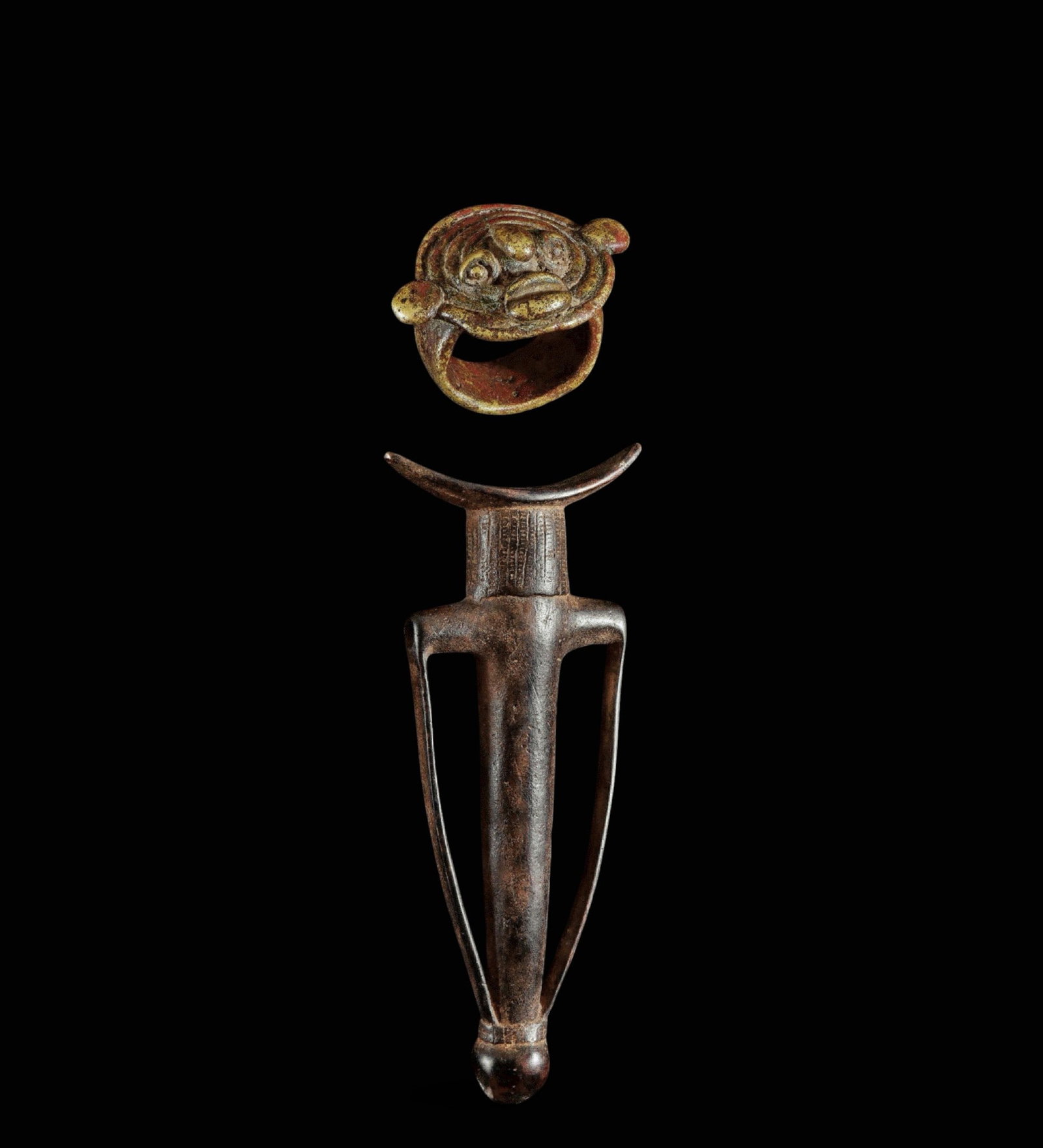 Flute and ring with mask representation, Gurunsi, Burkina Faso, 19th-20th centuries: Copper alloy. Measurements: 3.5 cm and 21 cm. Set consisting of a small flute and a ring made of copper alloy, the latter decorated with a stylized mask. The pieces exhibit handcrafted workmanship of 