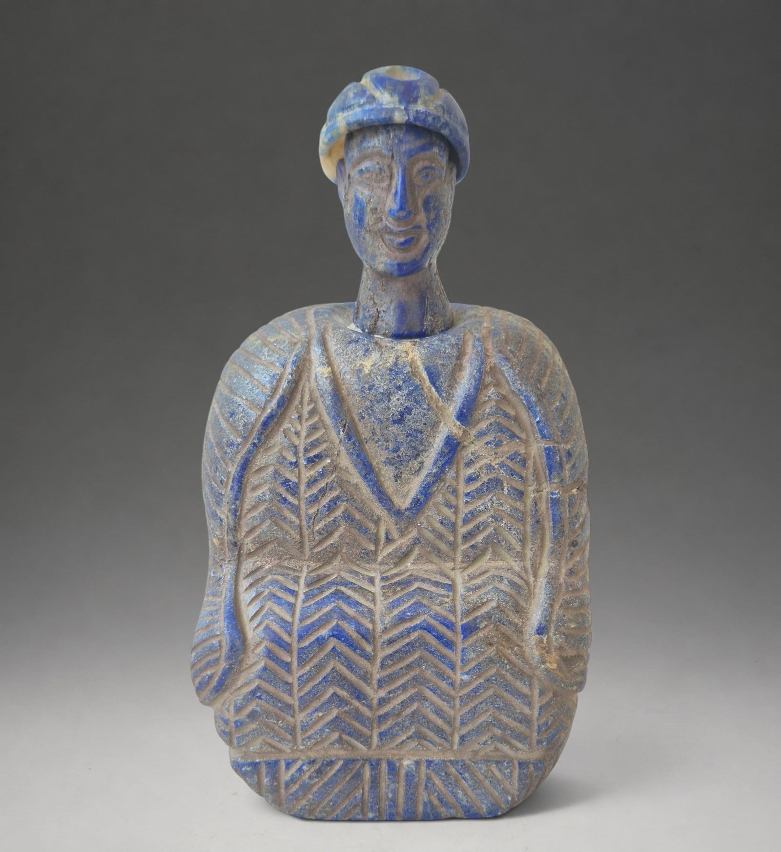 Bactrian composite stone idol with copper headdress, Bactria, late 3rd–early 2nd millennium BC.: Cream-colored limestone and copper. Dimensions: approximately 12.5 cm high × 11.5 cm wide. Weight: approximately 702 g. Anthropomorphic figure in the Bactrian tradition, carved from cream-colored lim