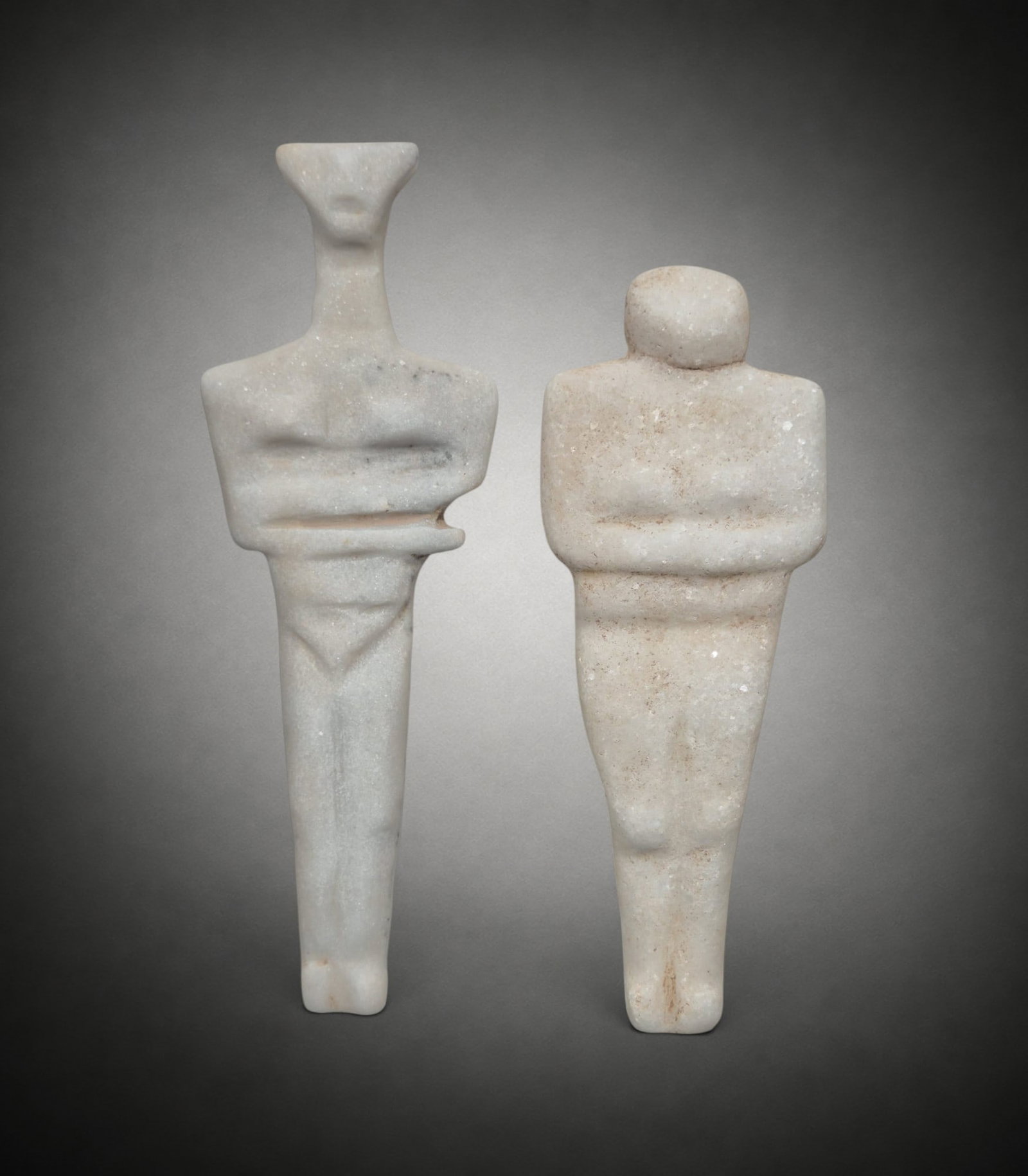 Neolithic steatopygous female figurine in white marble, Eastern Europe / Black Sea region, c.: White marble. Measurements: approximately 26.5 cm high × 9 cm wide at arm's length. Neolithic female figure with a marked stylization, featuring a very elongated and narrow body, a schematic trapezoi