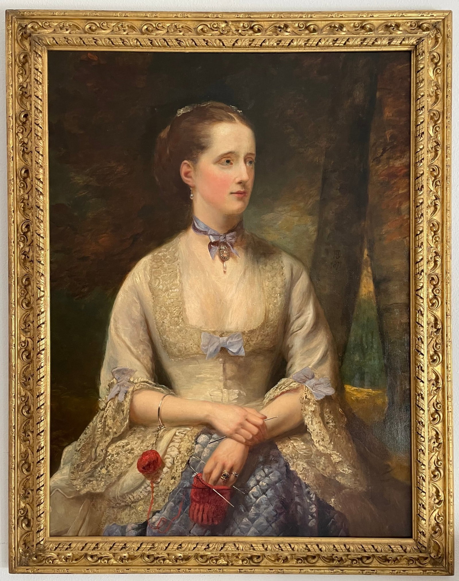 Henry Richard Graves (London, 1818–1882) – Portrait of a Lady, possibly Geraldine Georgiana Mary: Oil on canvas. Dimensions: 75 × 102 cm. Signed with the monogram HG and dated 1871. Three-quarter view portrait of an elegantly dressed lady, seated and engaged in needlework, with a ball of red yarn