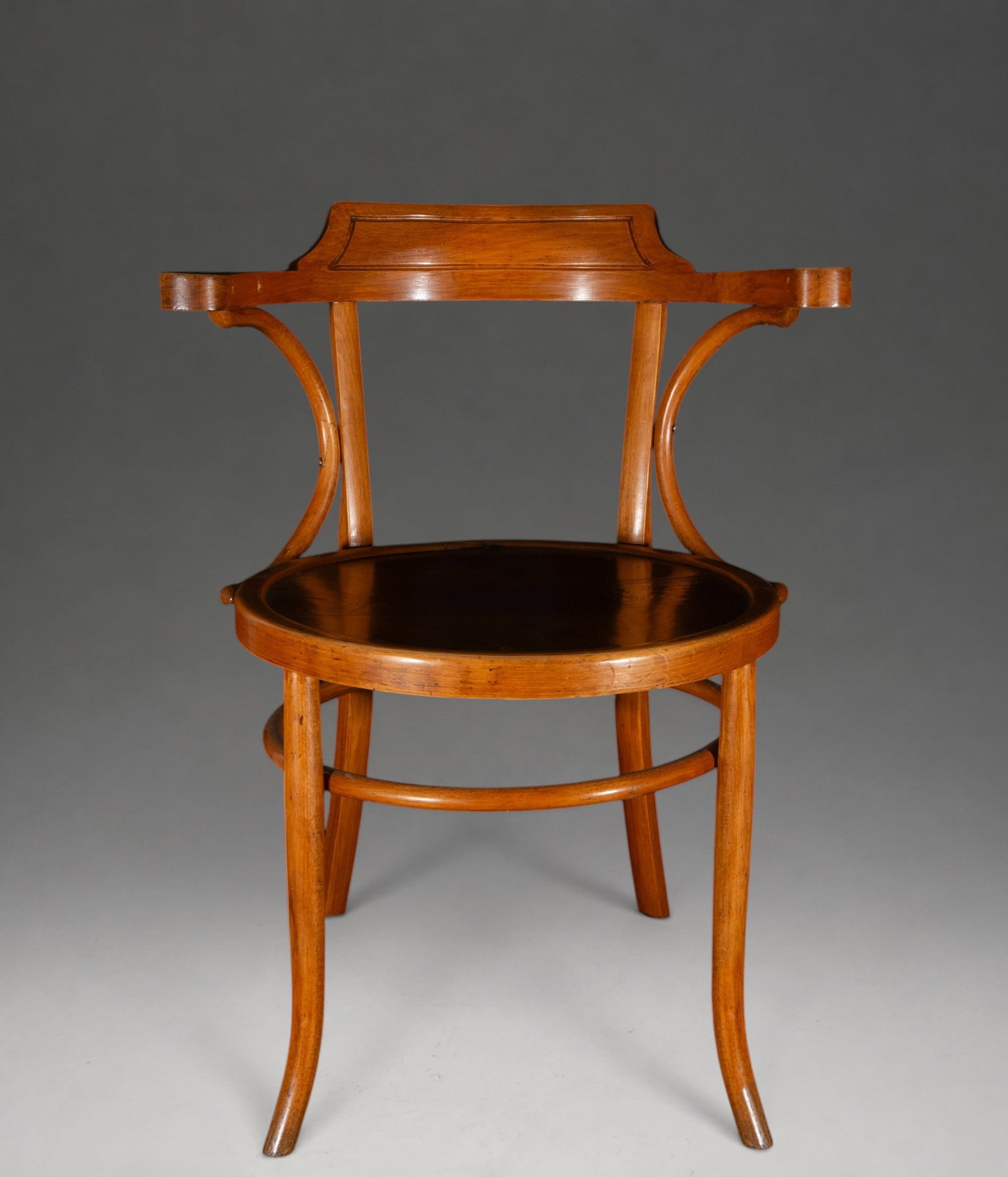 Art Nouveau bentwood armchair with marquetry seat – circa 1900: Art Nouveau bentwood armchair. Dimensions: 90 × 62 × 50 cm. The structure features sinuous lines with slightly arched legs, a lower reinforcing ring, extended arms, and a perforated backrest articul