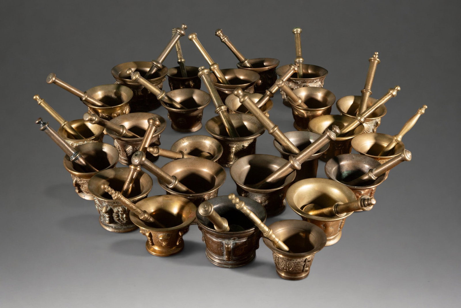 Collection of twenty-four bronze mortars with their handles: A set of twenty-four bronze mortars, each accompanied by its respective pestle, of varying sizes and styles. Approximate dimensions range from 6 × 10 × 10 cm (smallest) to 9 × 15 × 15 cm (largest)