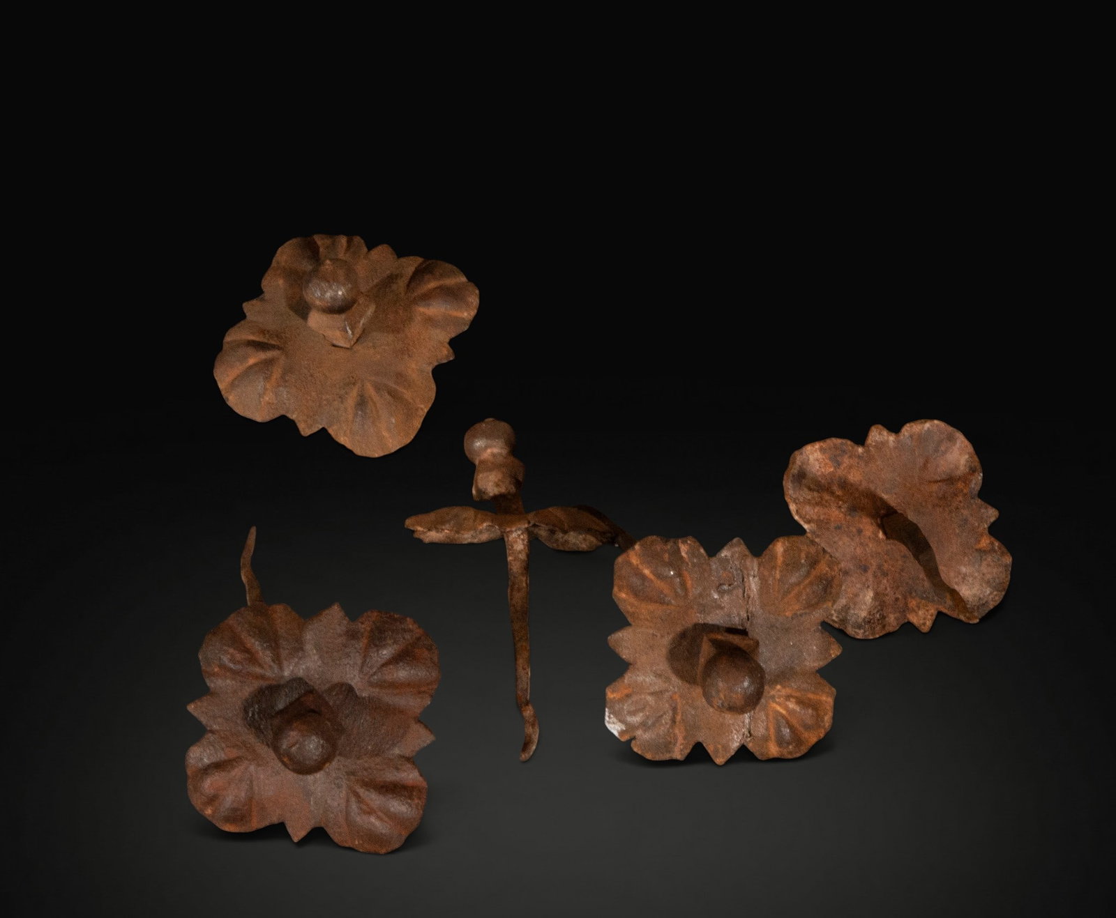 Set of 63 decorative wrought iron nails – 19th century: A set of 63 wrought iron nails and decorative elements, several with heads cut in the shape of flowers or rosettes. Approximate dimensions per unit: 6 x 6 cm. They retain a marked oxidation and surfac