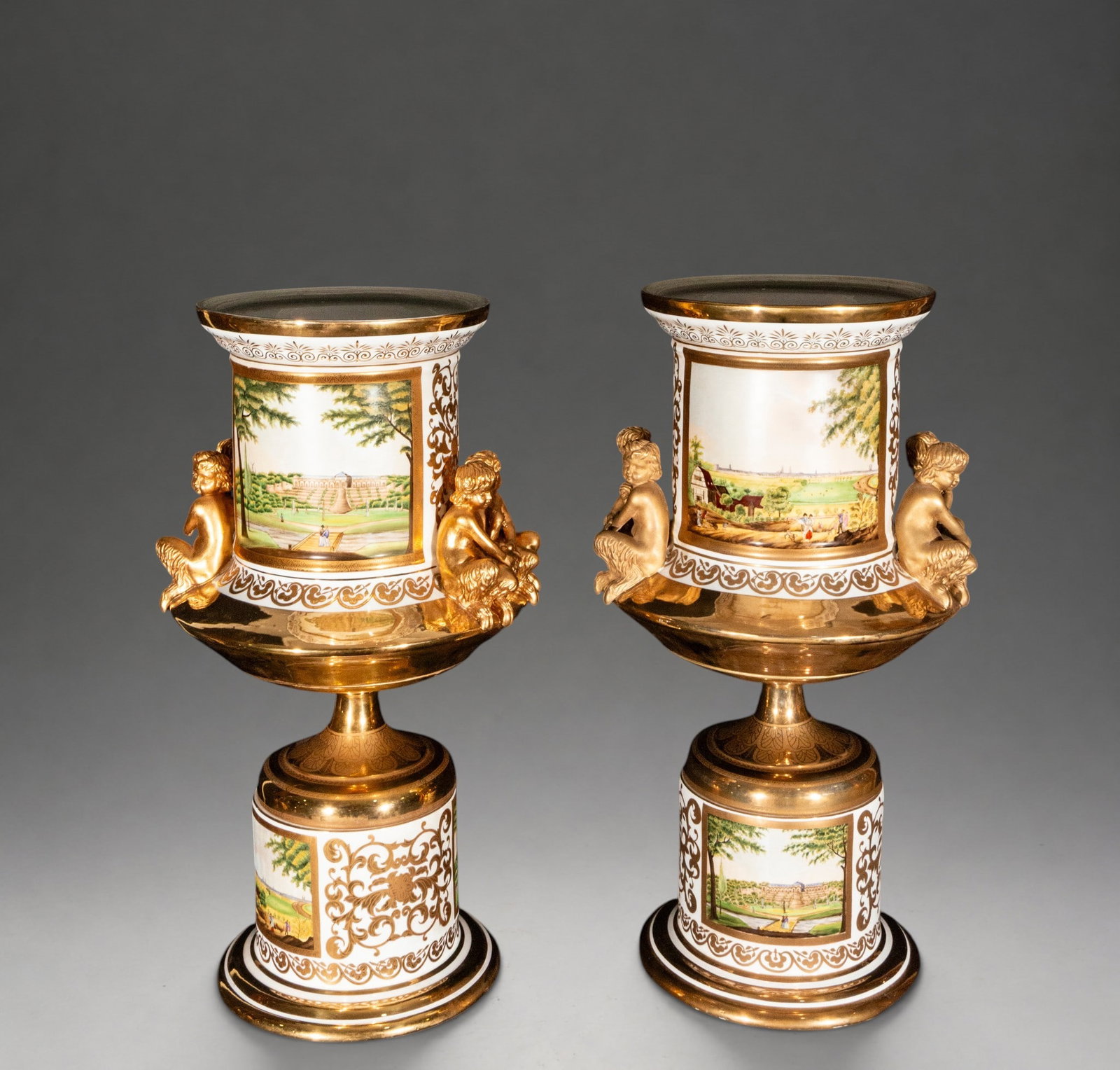 Pair of vases with palace views and gilded figures, marked KPM – Germany – 19th century: Pair of German porcelain vases, lavishly gilded and decorated with polychrome reserves depicting palace views, gardens, and countryside scenes. Each piece features gilded female figures applied around