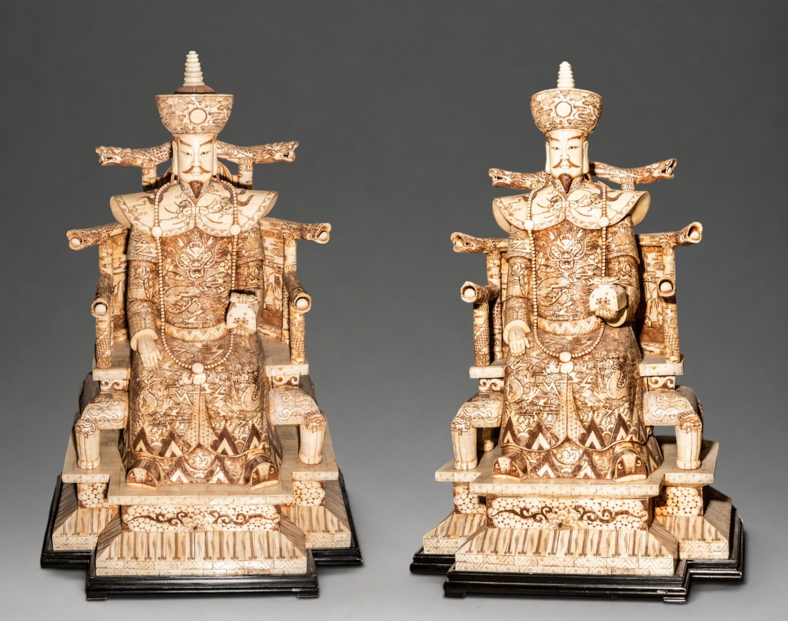 MONUMENTAL COUPLE OF CHINESE DIGNITARIES IN BONE - EARLY 20TH CENTURY: Dimensions: 120 × 70 × 58 cm. Pair of large seated figures of Chinese emperors made of a wooden frame covered with carved and incised bone plaques, with decoration highlighted in brown tones. The fi