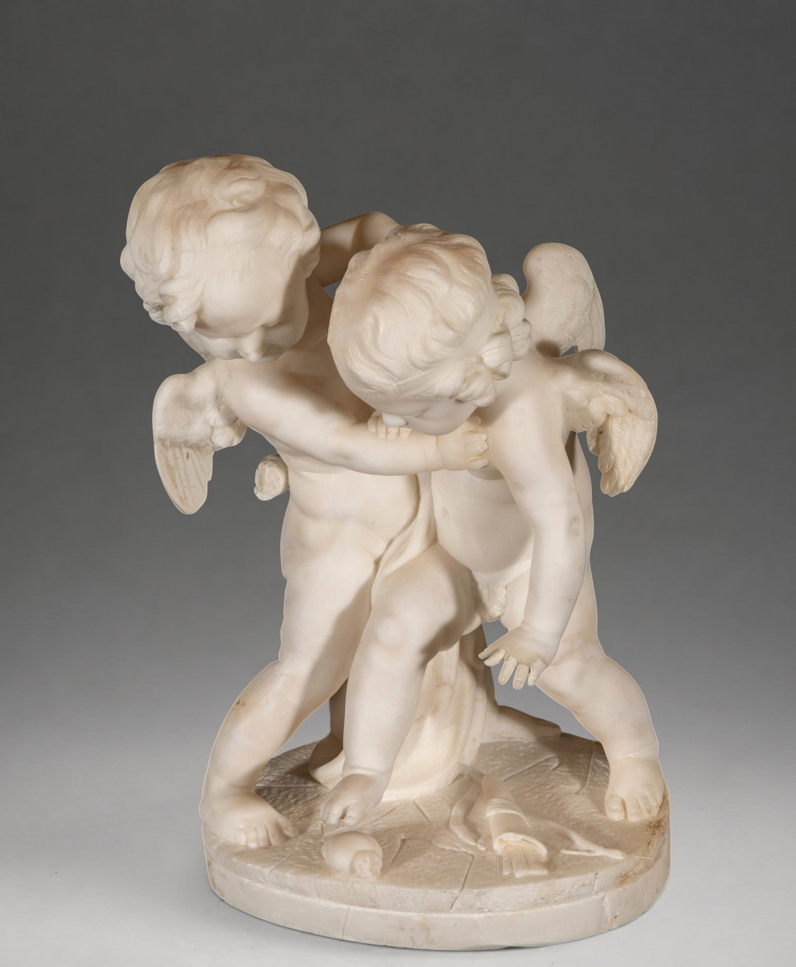 Important pair of 19th-century Cupids, in marble, Italy: Carved and polished white marble. Sculptural group consisting of two winged, nude cherubs, depicted embracing in an affectionate and dynamic pose. The figures have wavy hair, meticulously crafted wing